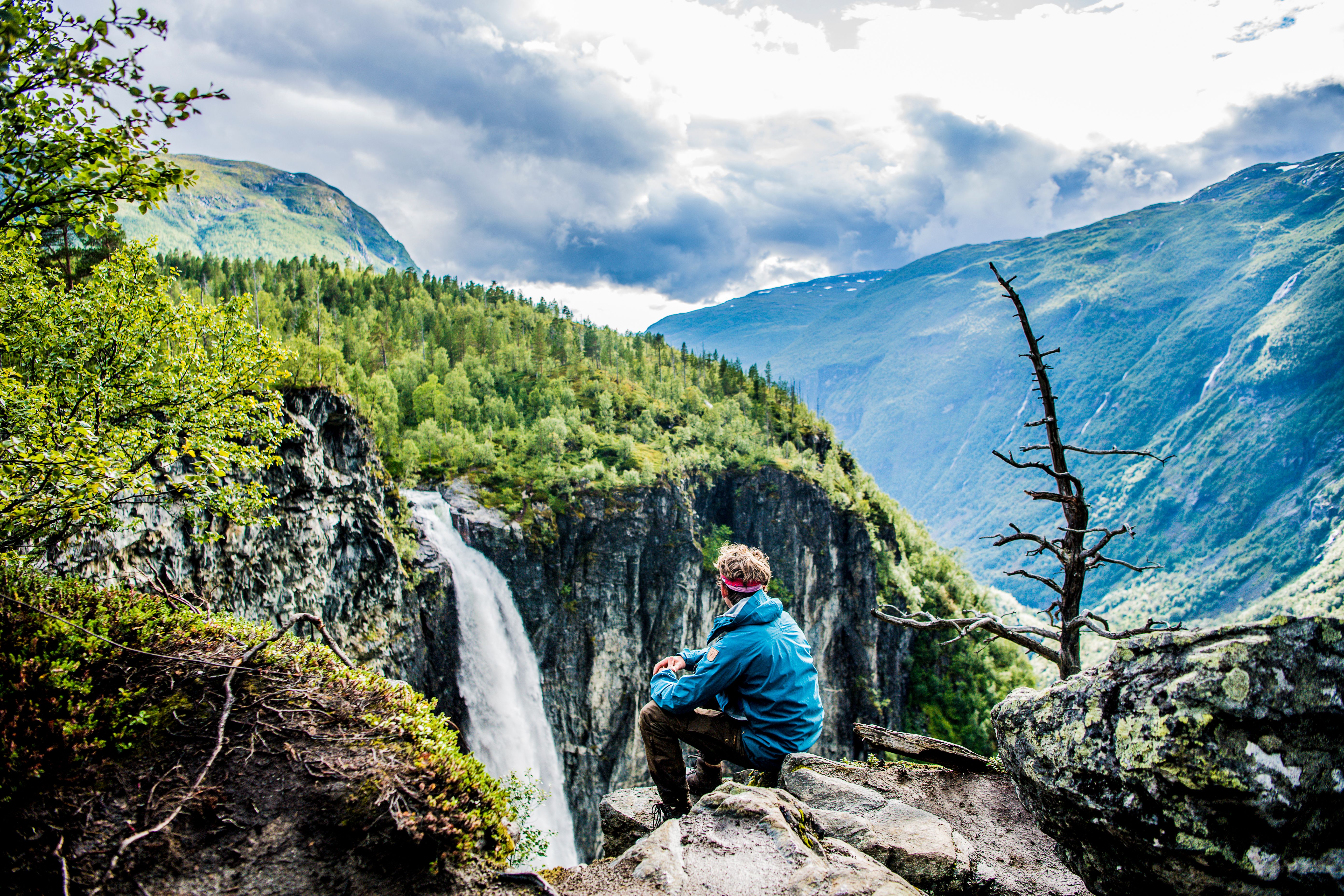 A man enjoying the view of the Vettisfossen waterfall in Utladalen in the Jotunheimen mountains, Norway