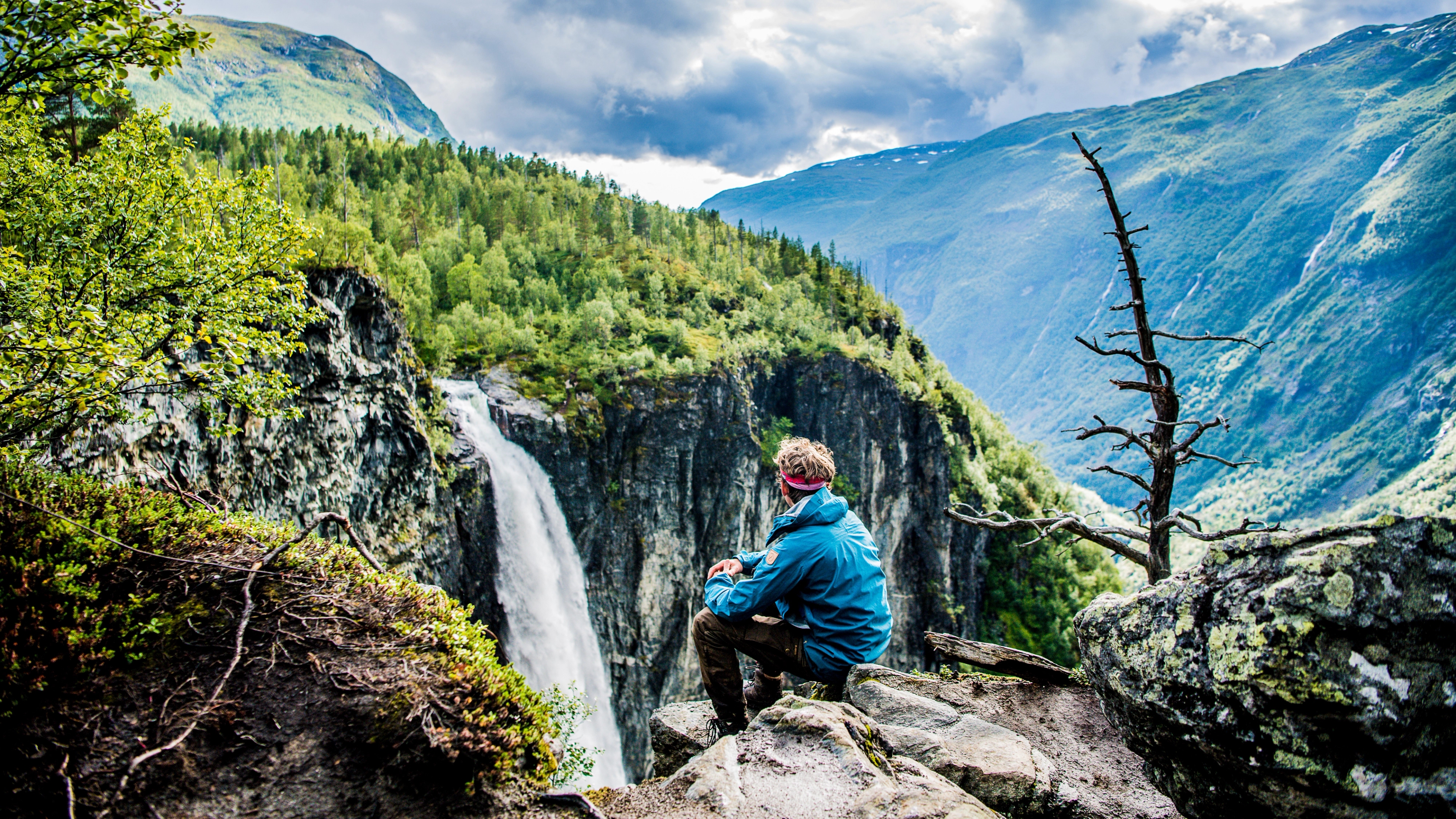 A man enjoying the view of the Vettisfossen waterfall in Utladalen in the Jotunheimen mountains, Norway