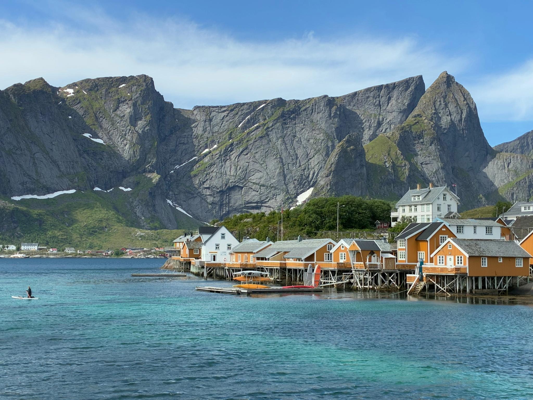 Norwegian fishing village on stilts over water with mountains in the background