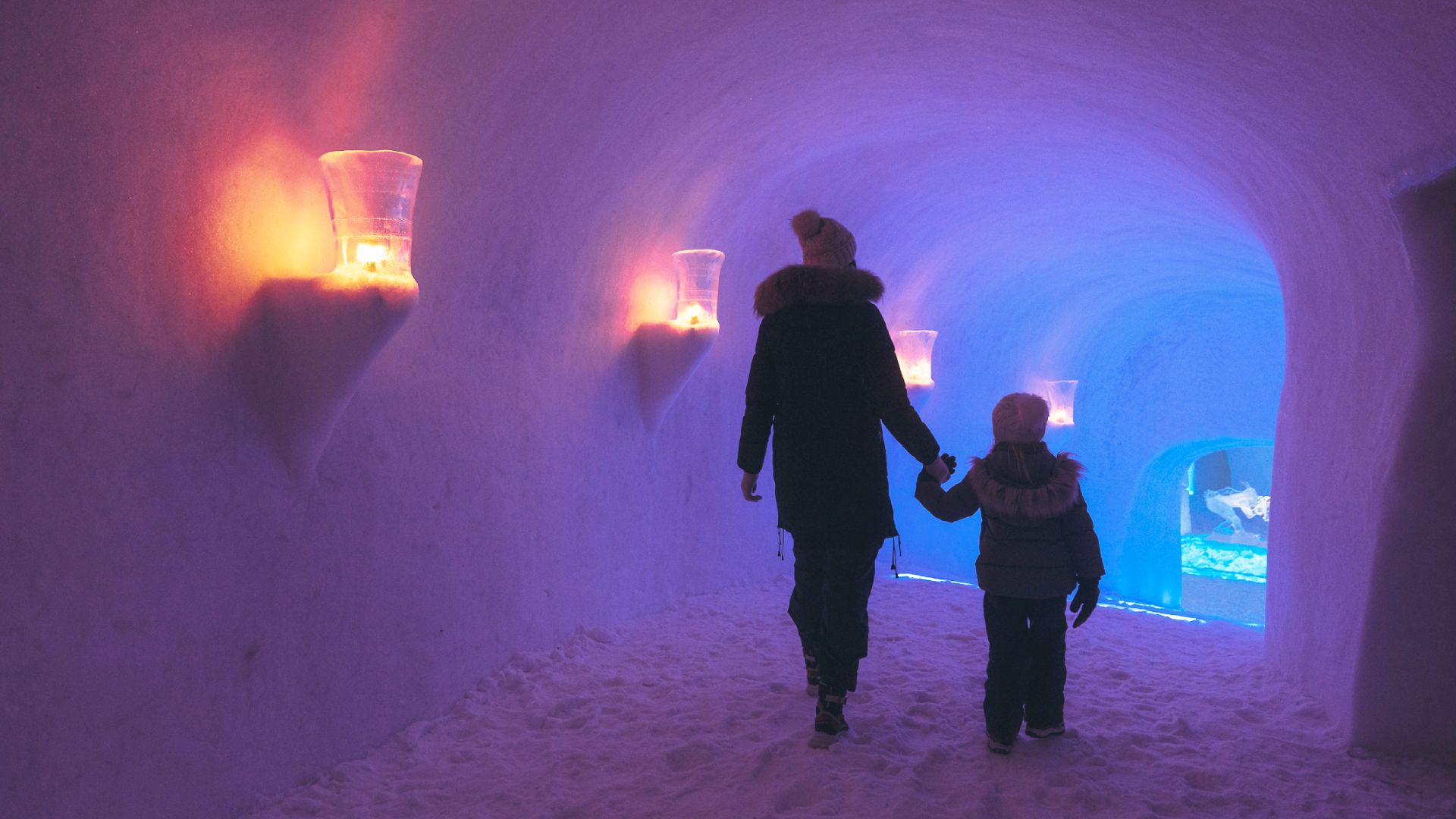Woman and kid walking in a corridor of Hunderfossen Snow Hotel