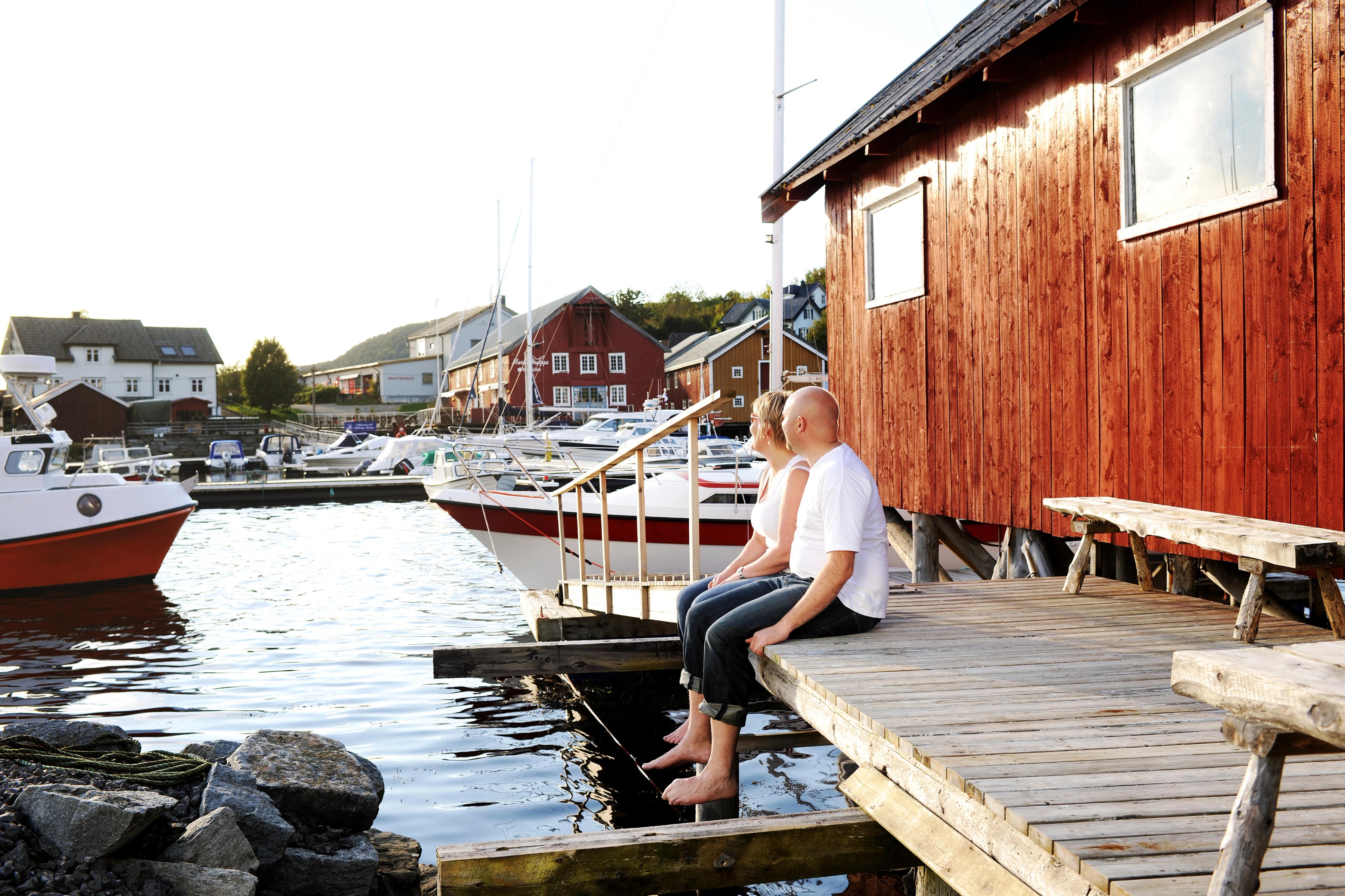 A couple enjoying life outside a fisherman's cabin in Råkvåg, Fosen