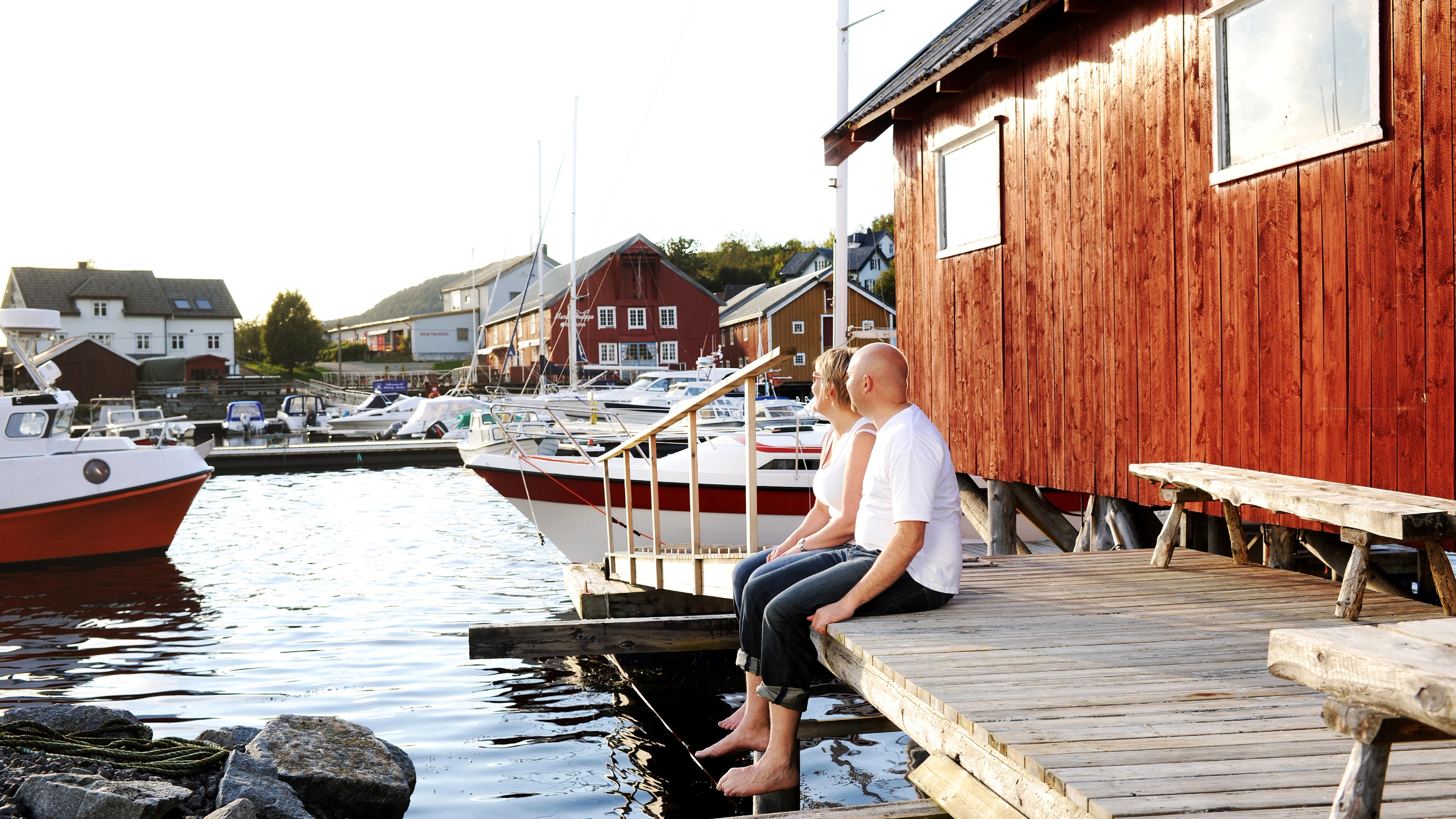 A couple enjoying life outside a fisherman's cabin in Råkvåg, Fosen