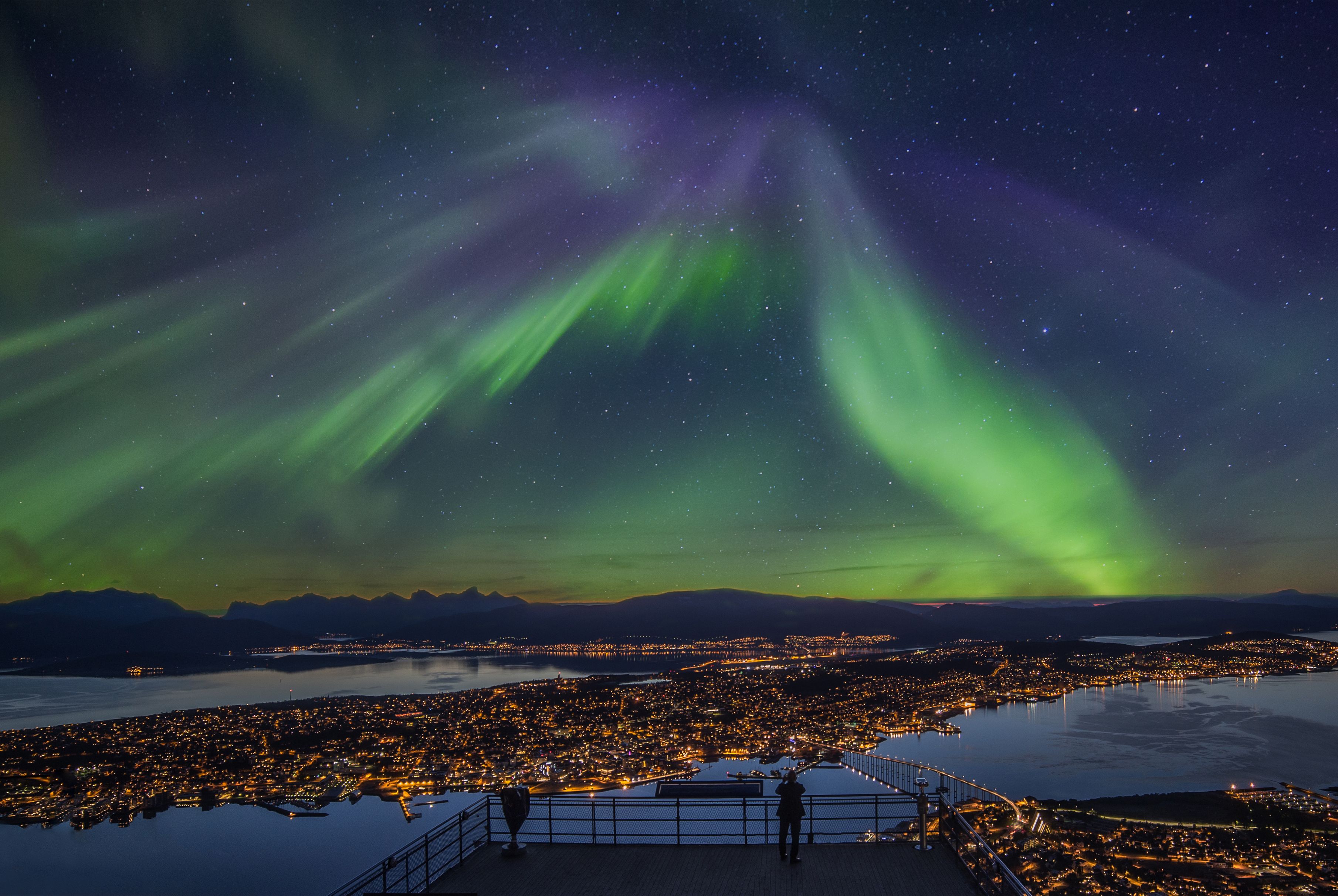 Green and violet Northern Lights over the arctic city of Tromsø in Northern Norway