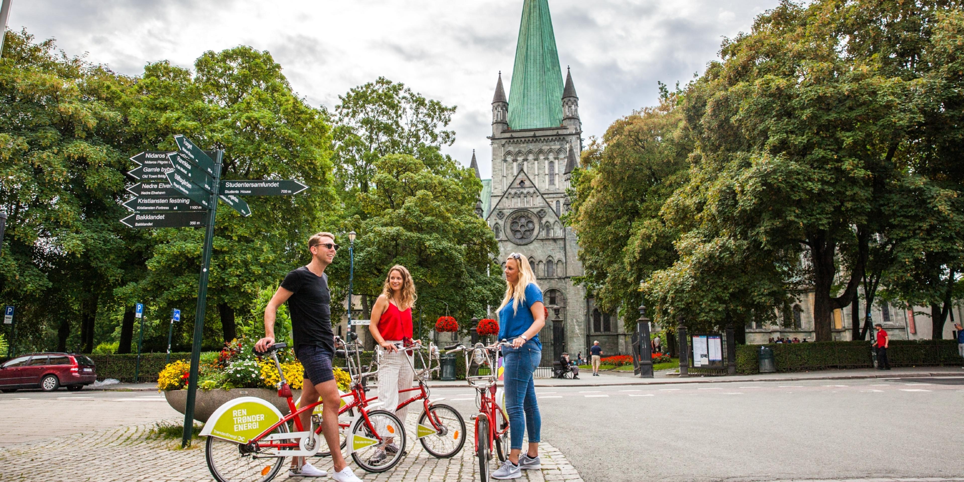 Three people with bikes on a city break in Trondheim, Norway