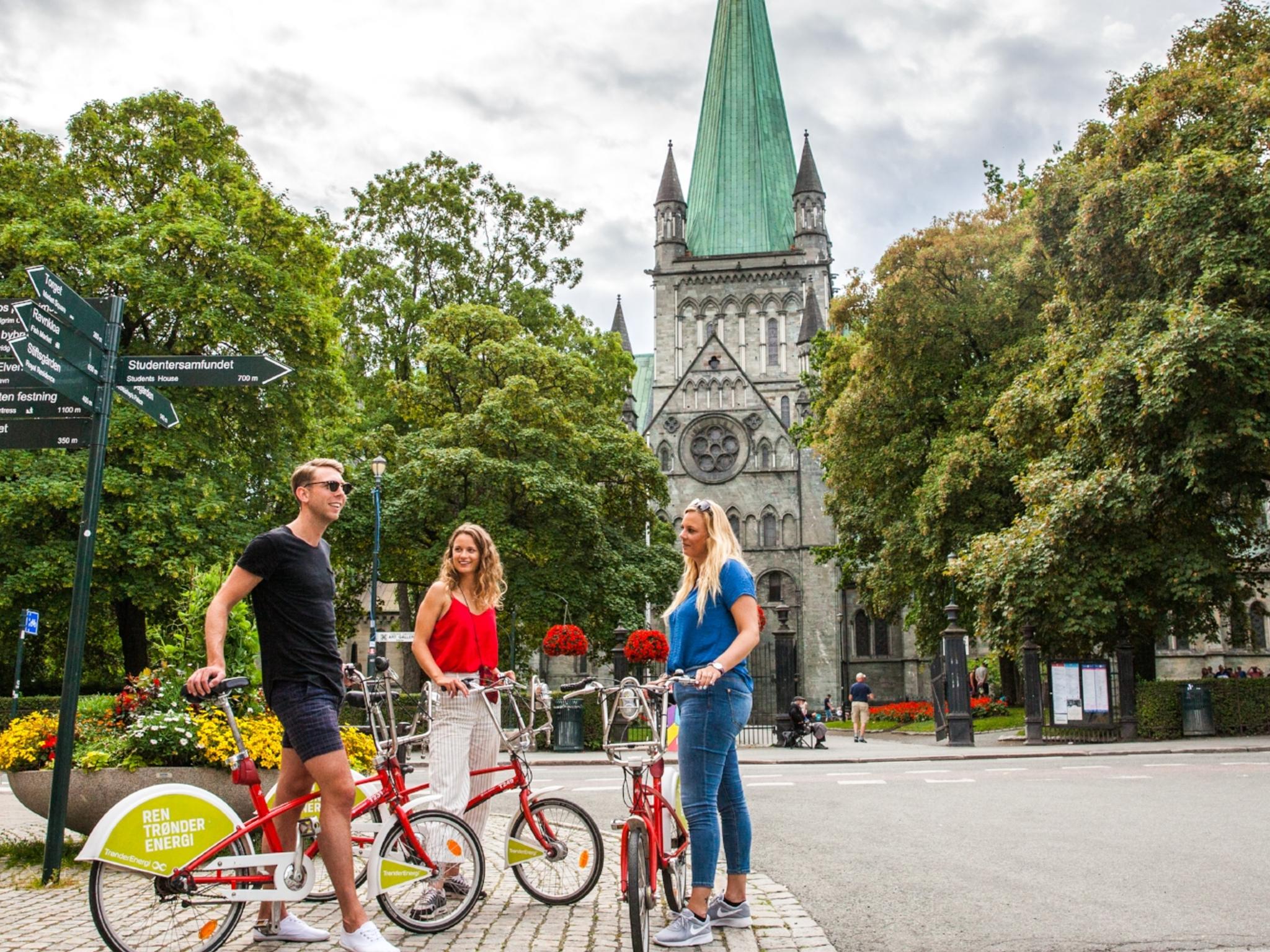 Tre personer med cyklar på besök i Trondheim, Norge