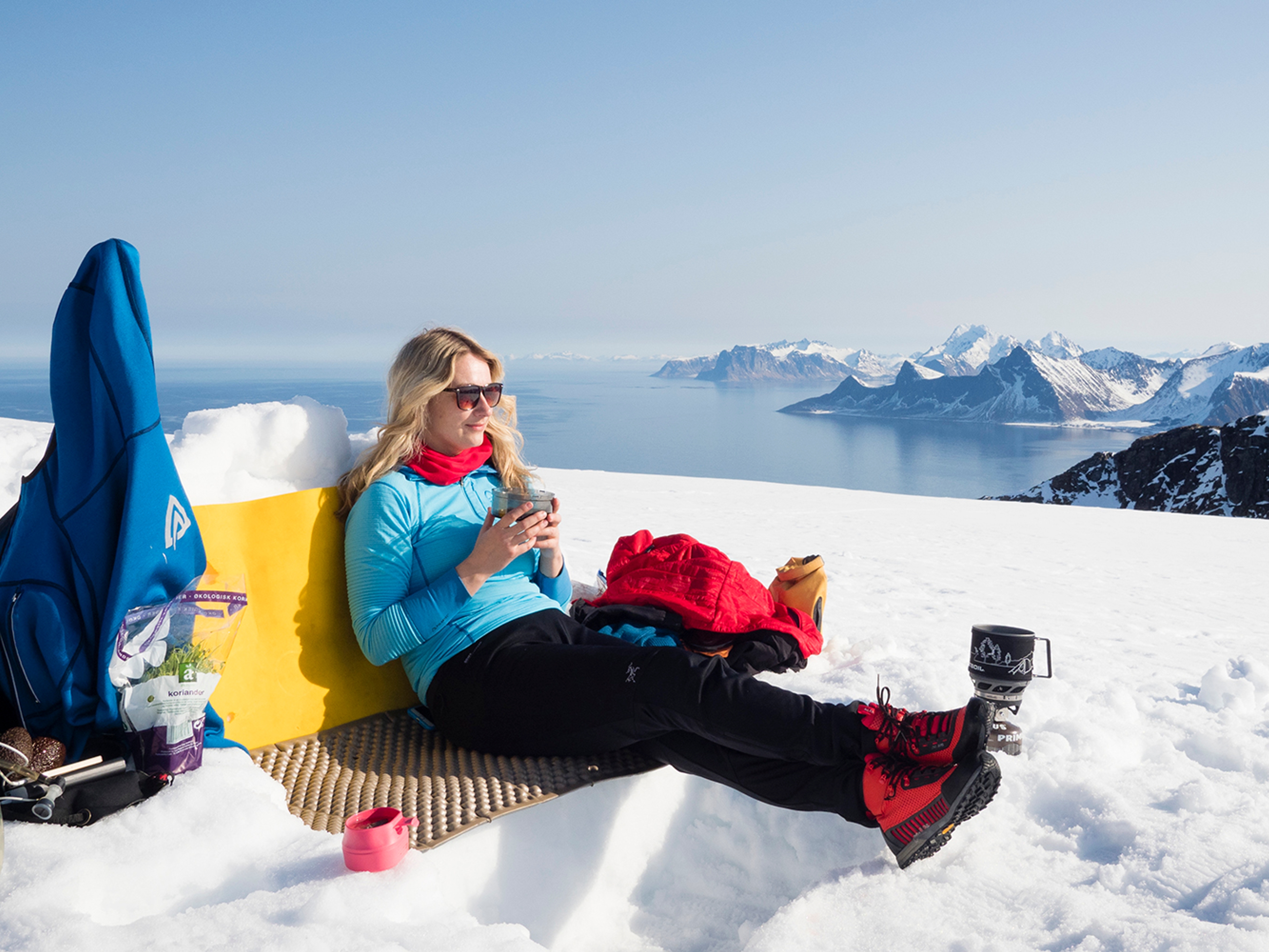 Woman enjoying a break on a winter hike to Mount Ryten in Lofoten, Northern Norway