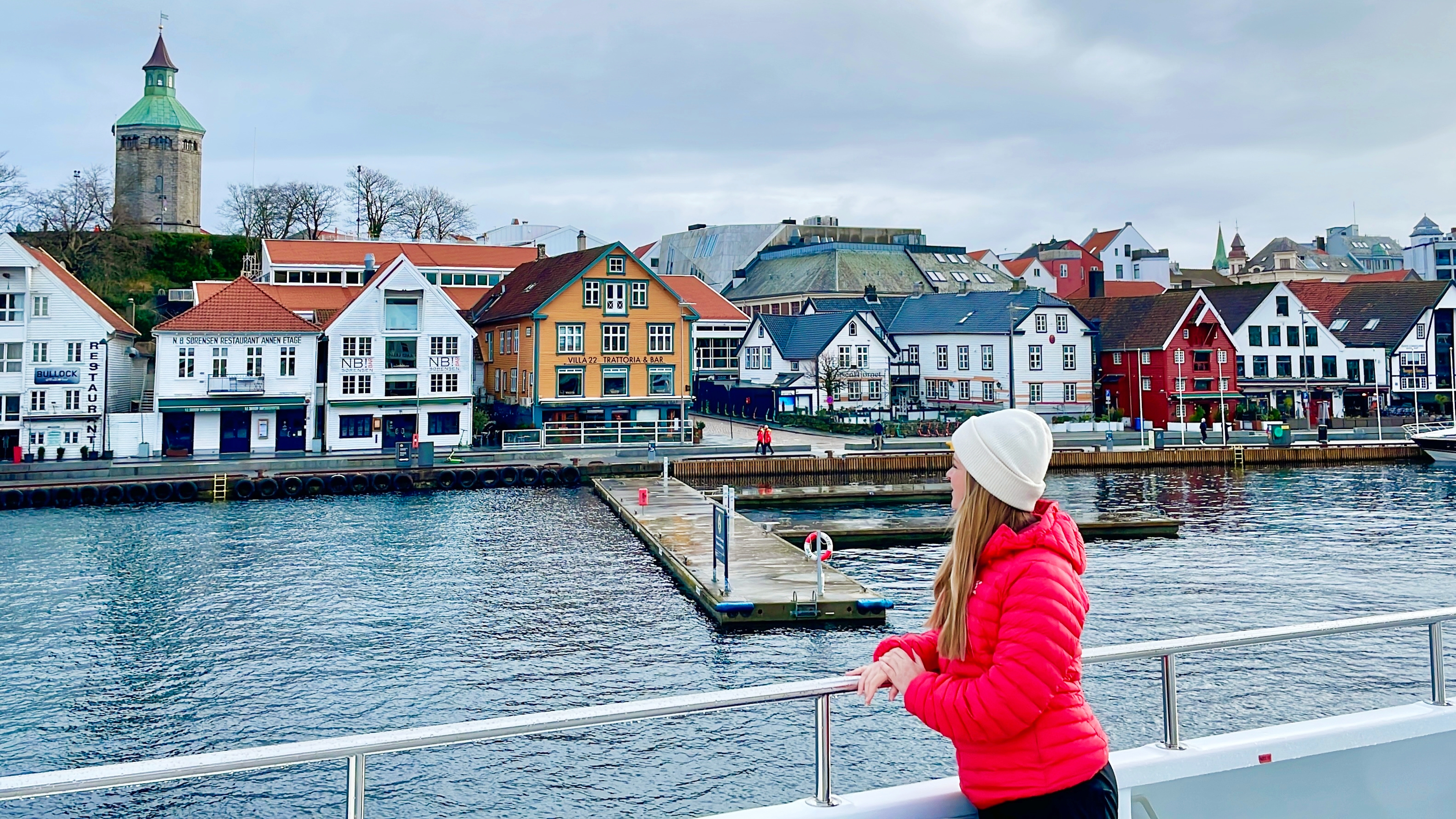 A woman standing on a cruise ship with view to the harbour of Stavanger