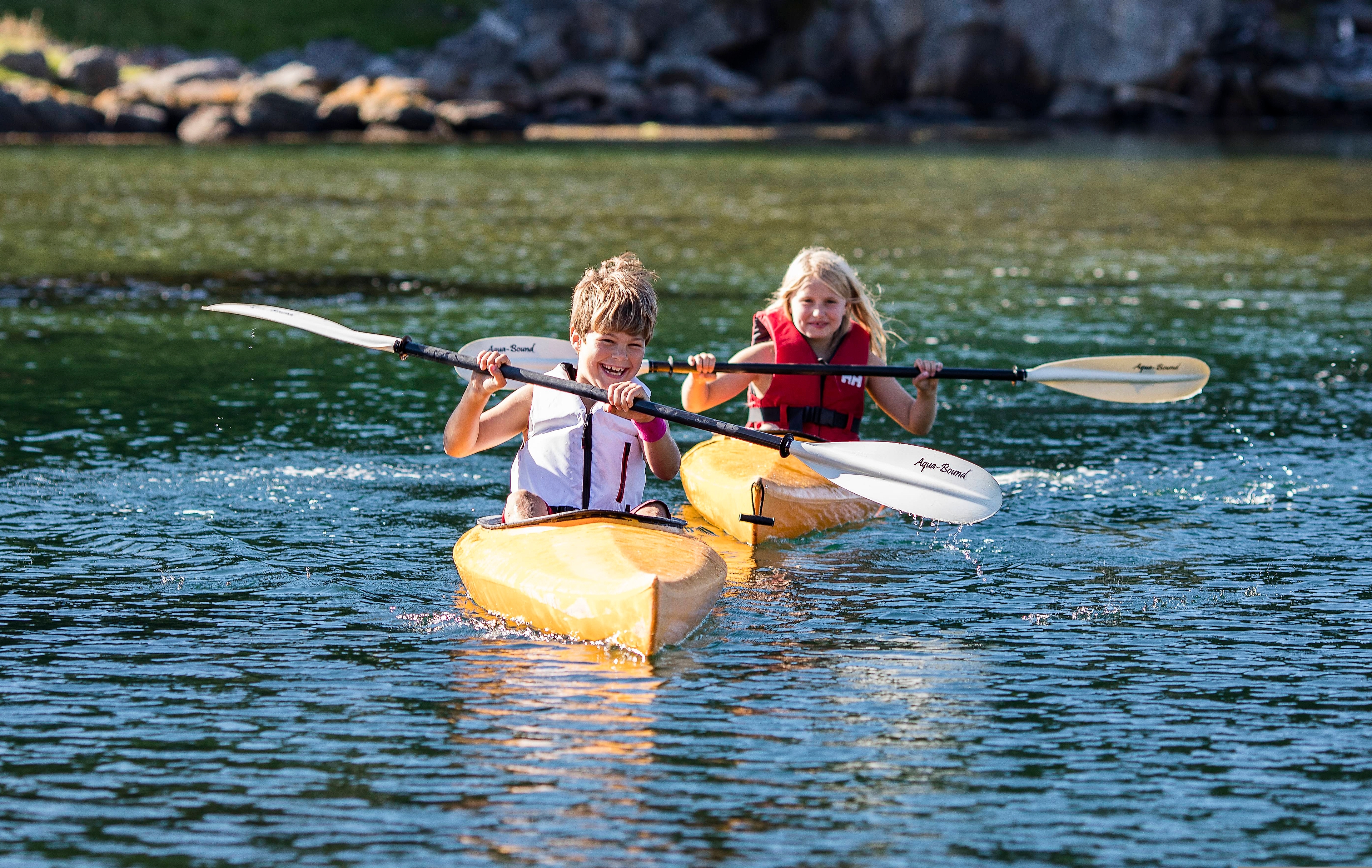 Two children are kayaking in the waters by the island Hidra outside Flekkefjord in Southern Norway