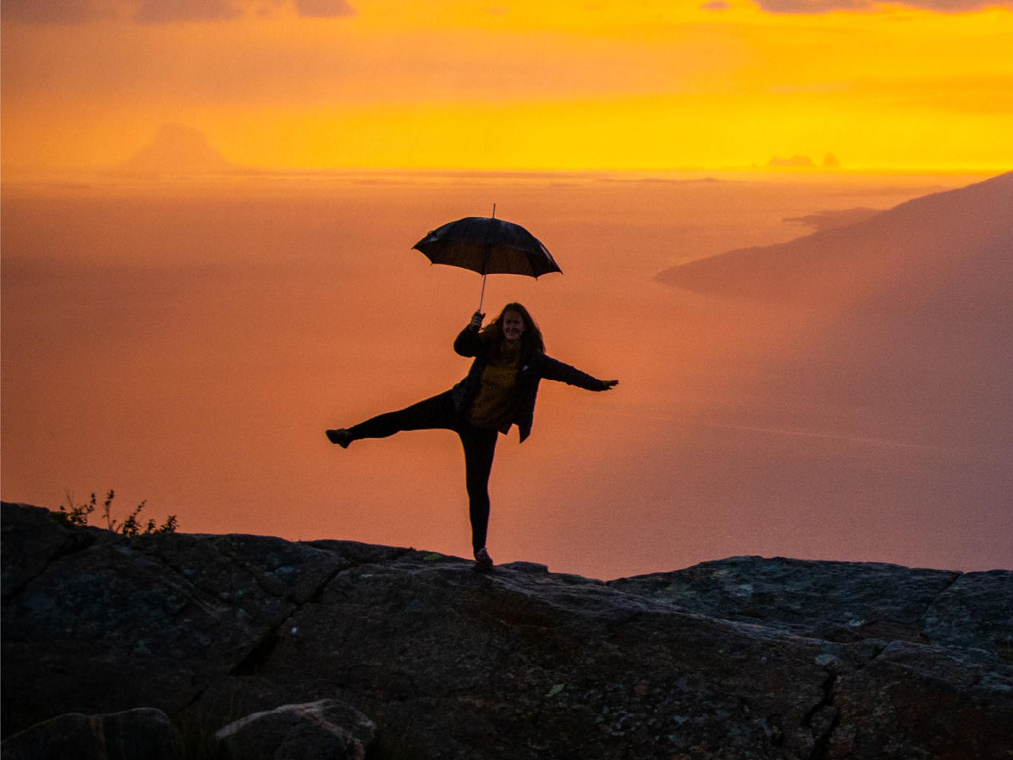 Girl holding an umbrella at the Sjonfjellet mountain in Northern Norway