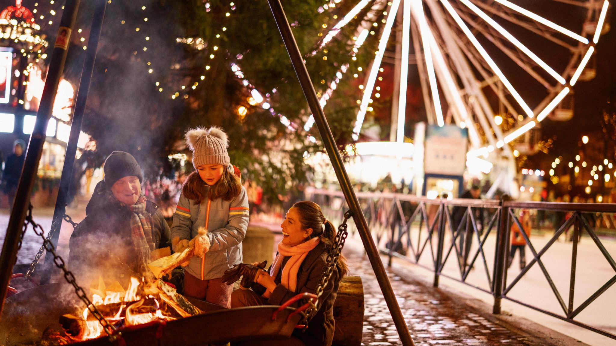 A family at Oslo Christmas market by the fire