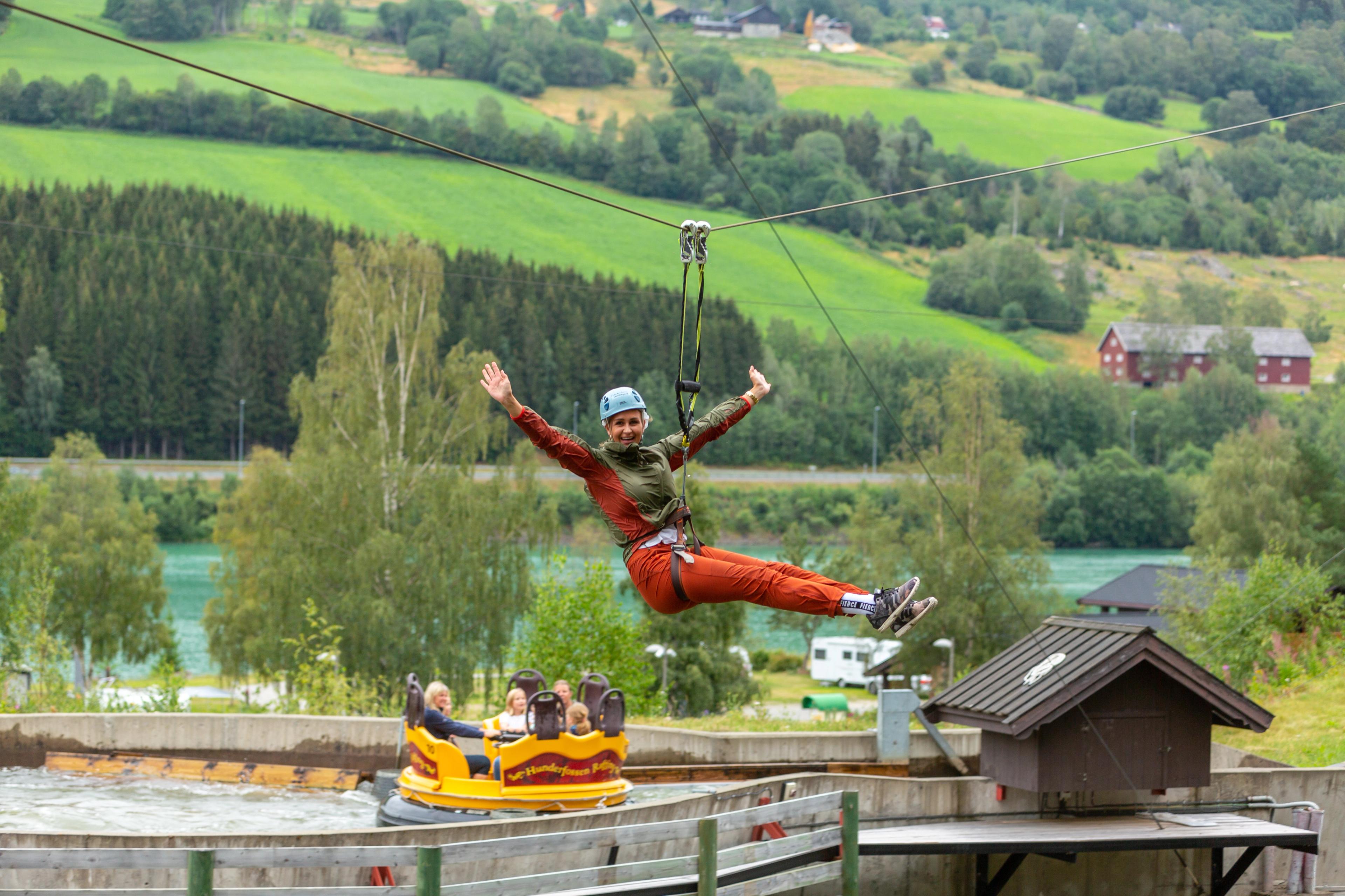A woman is flying down the zip line in Hunderfossen Adventure Park in Lillehammer, Eastern Norway