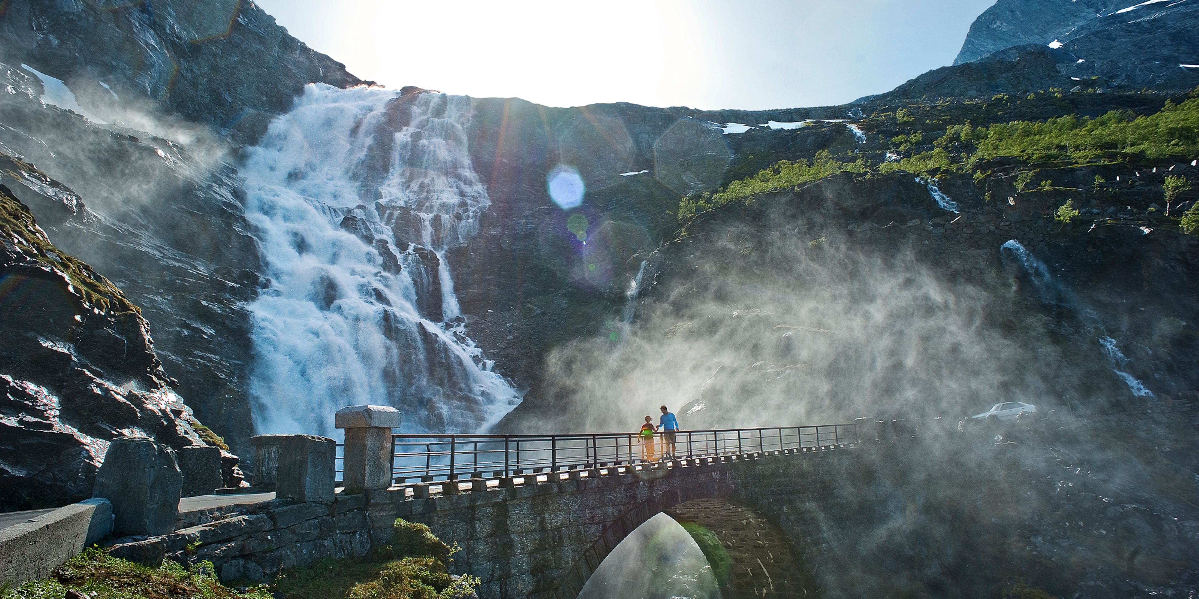 Two people running over a bridge at the Trollstigen road, in Rauma