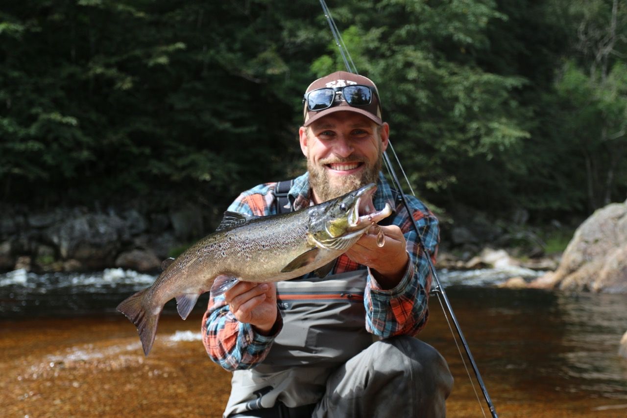 An angler is holding a salmon in Mandal, Southern Norway