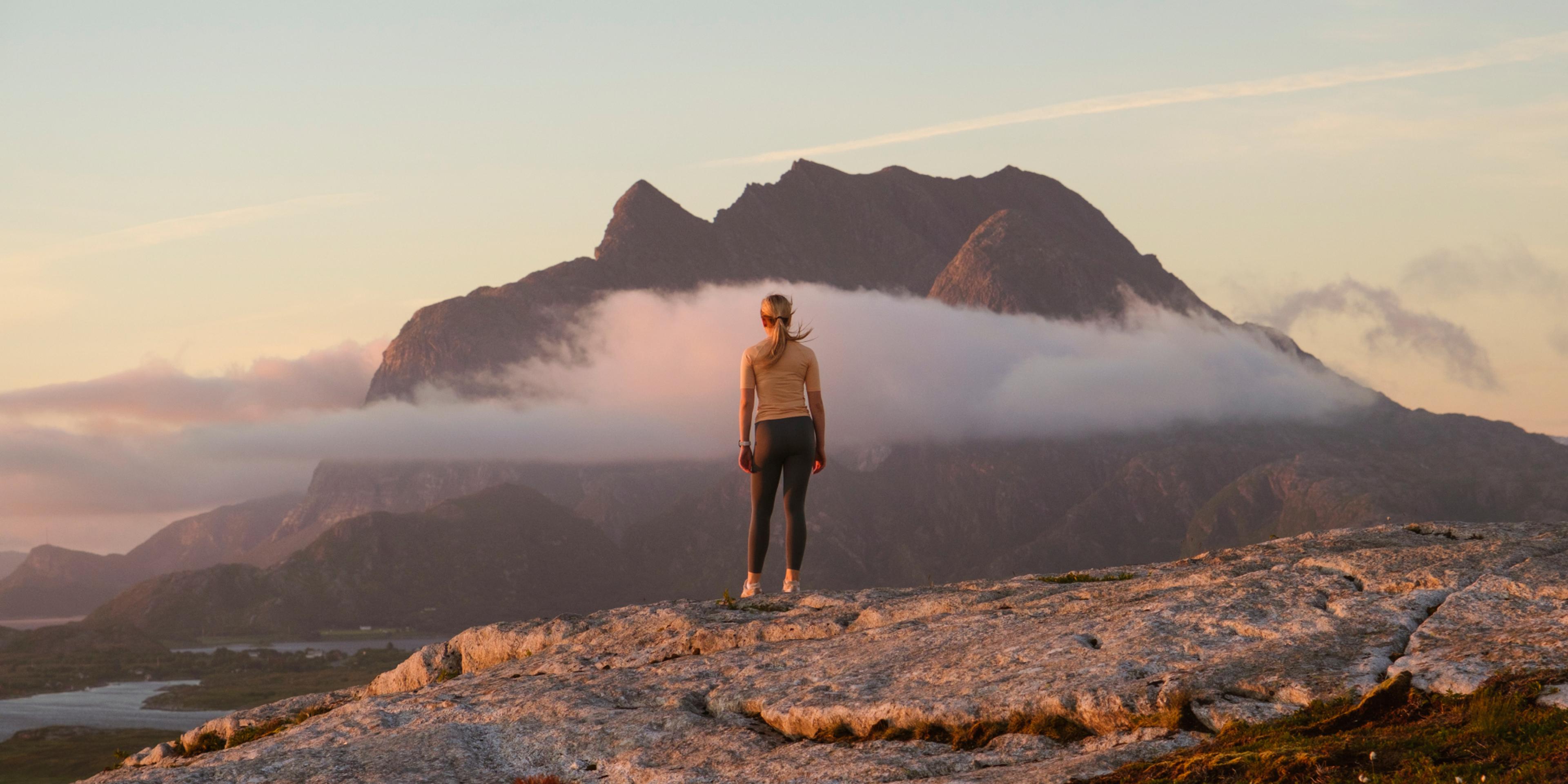 A woman going on a midnight hike to Øksningan, Helgeland, Norway.