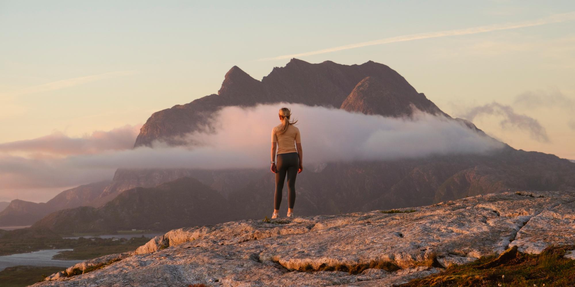 A woman going on a midnight hike to Øksningan, Helgeland, Norway.