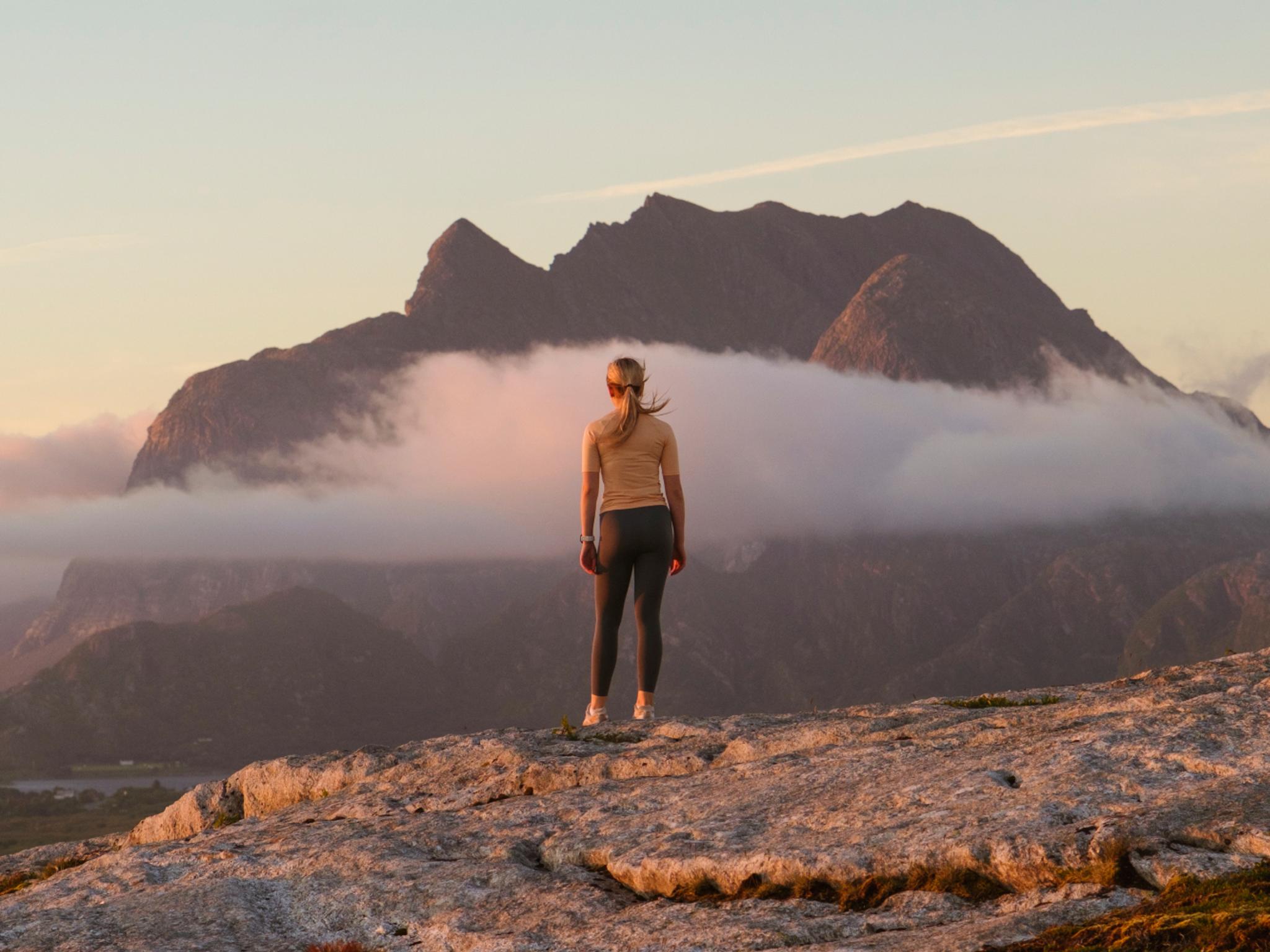 A woman going on a midnight hike to Øksningan, Helgeland, Norway.