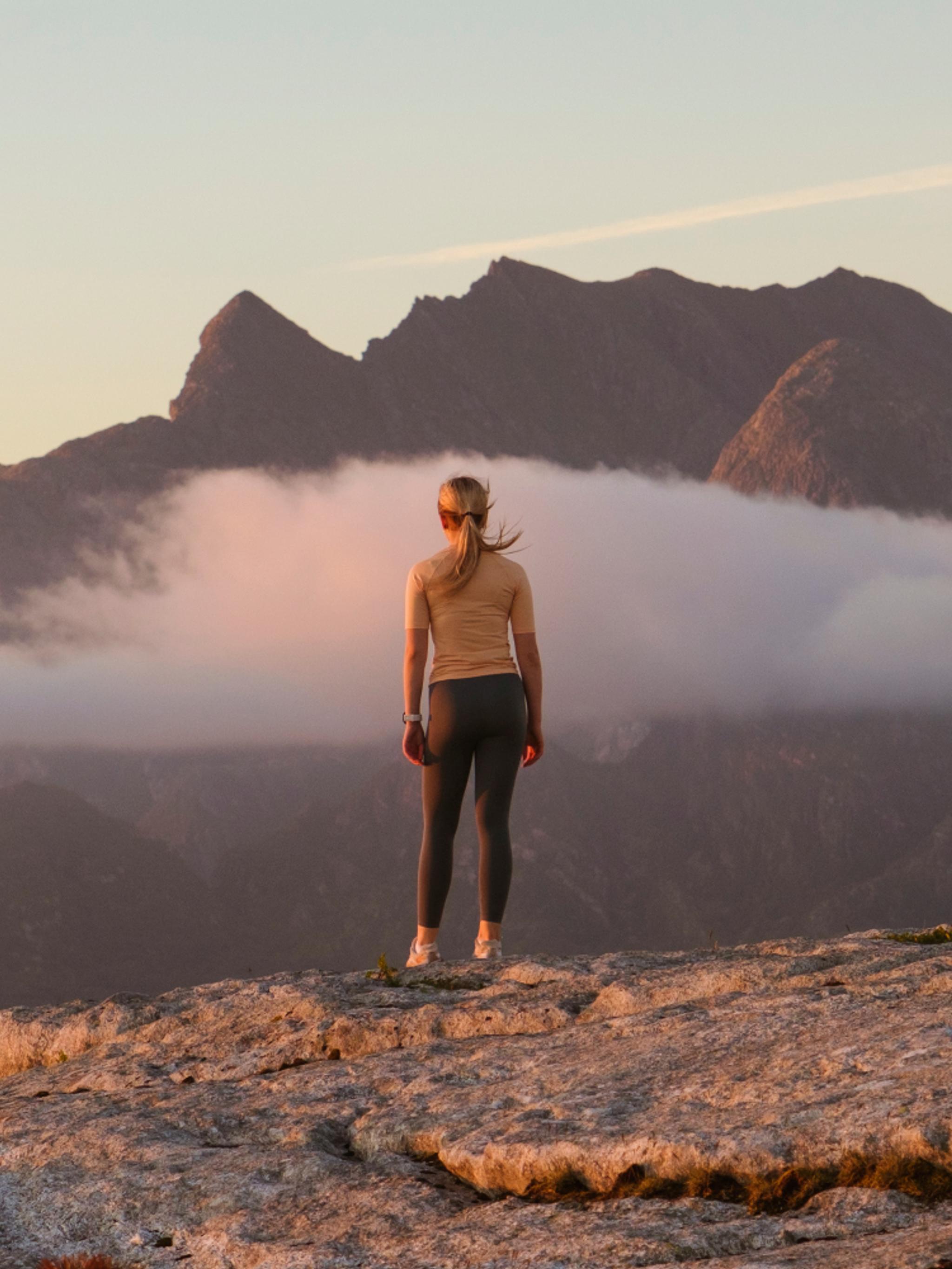 A woman going on a midnight hike to Øksningan, Helgeland, Norway.