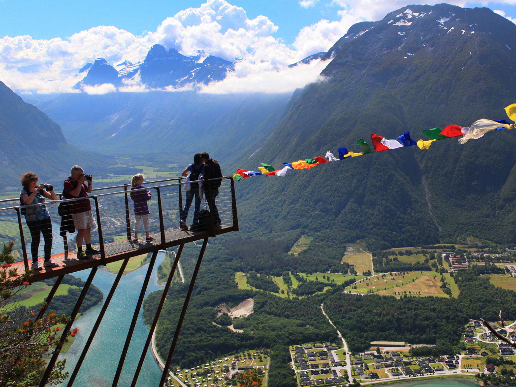 Wanderer blicken von der Aussichtsplattform Rampestreken auf die Stadt Åndalsnes im Nordwesten, Fjord Norwegen