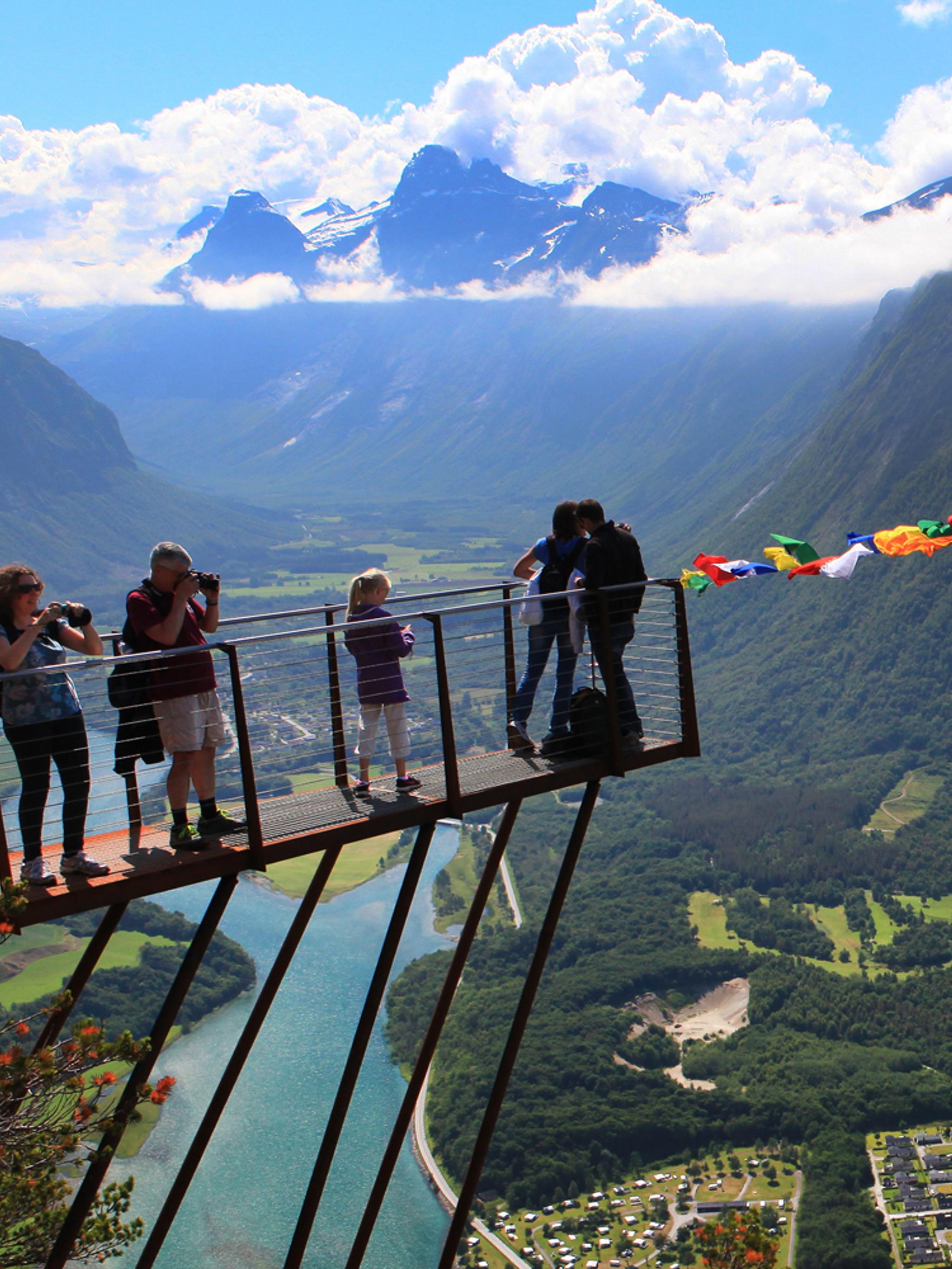 En grupp människor vid Rampestreken, med utsikt över staden Åndalsnes i området Nordvest som ligger i regionen Fjord Norge