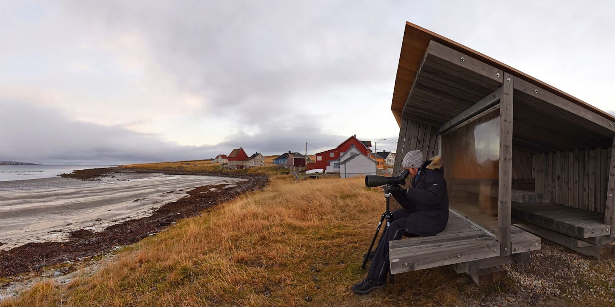 A person making pictures at a birdwatching shed near the water at Ekkerøy, Troms, Northern Norway