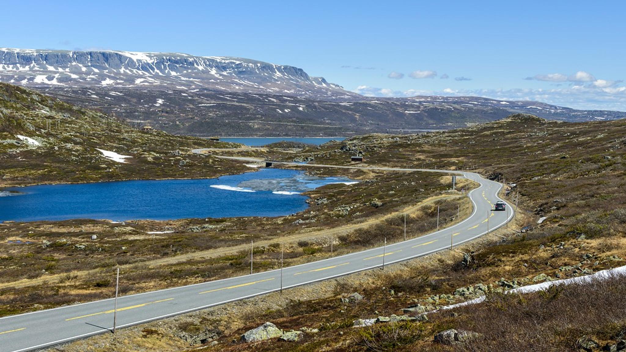 A car driving past lakes on a mountain plateau