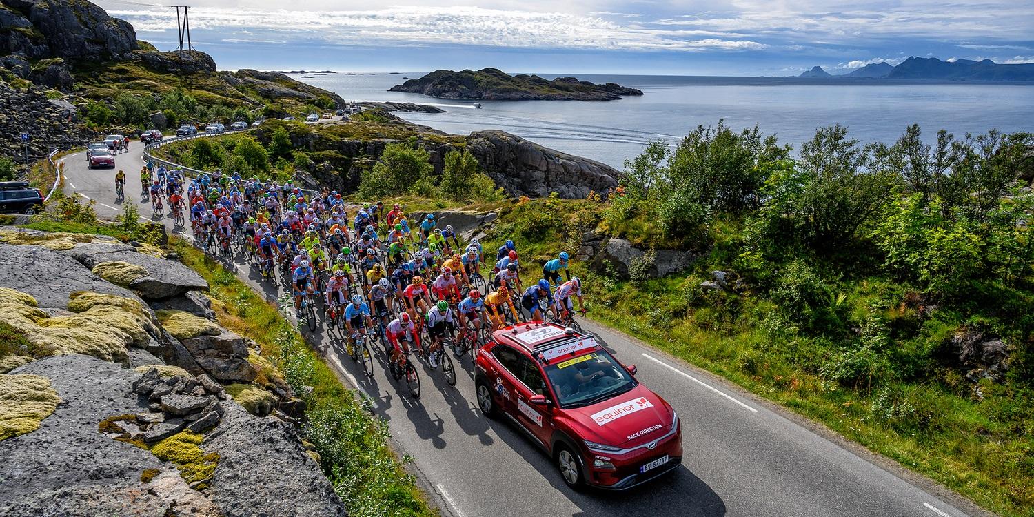 Professional bike riders cycling on a scenic road on Lofoten in Norway