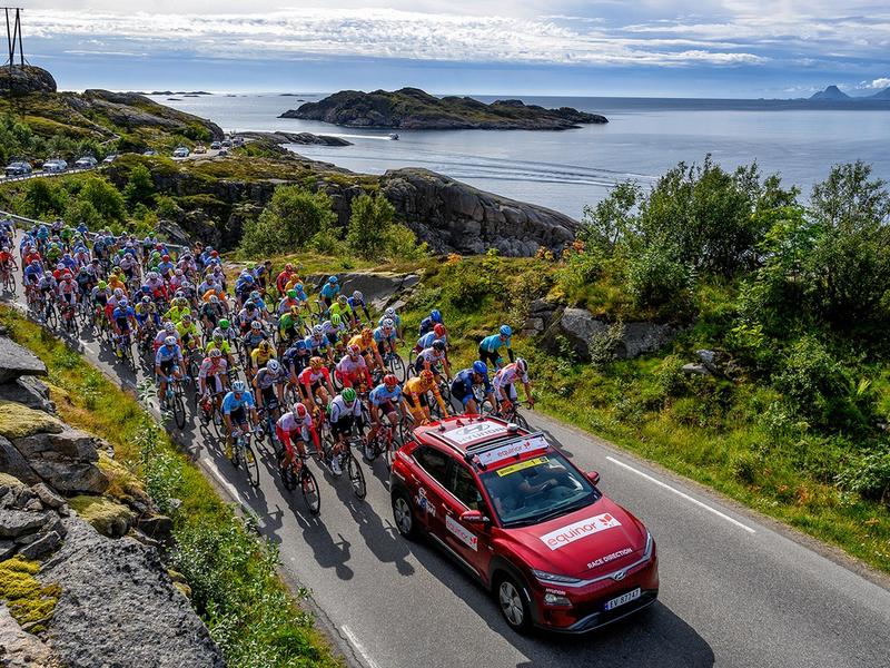 Professional bike riders cycling on a scenic road on Lofoten in Norway