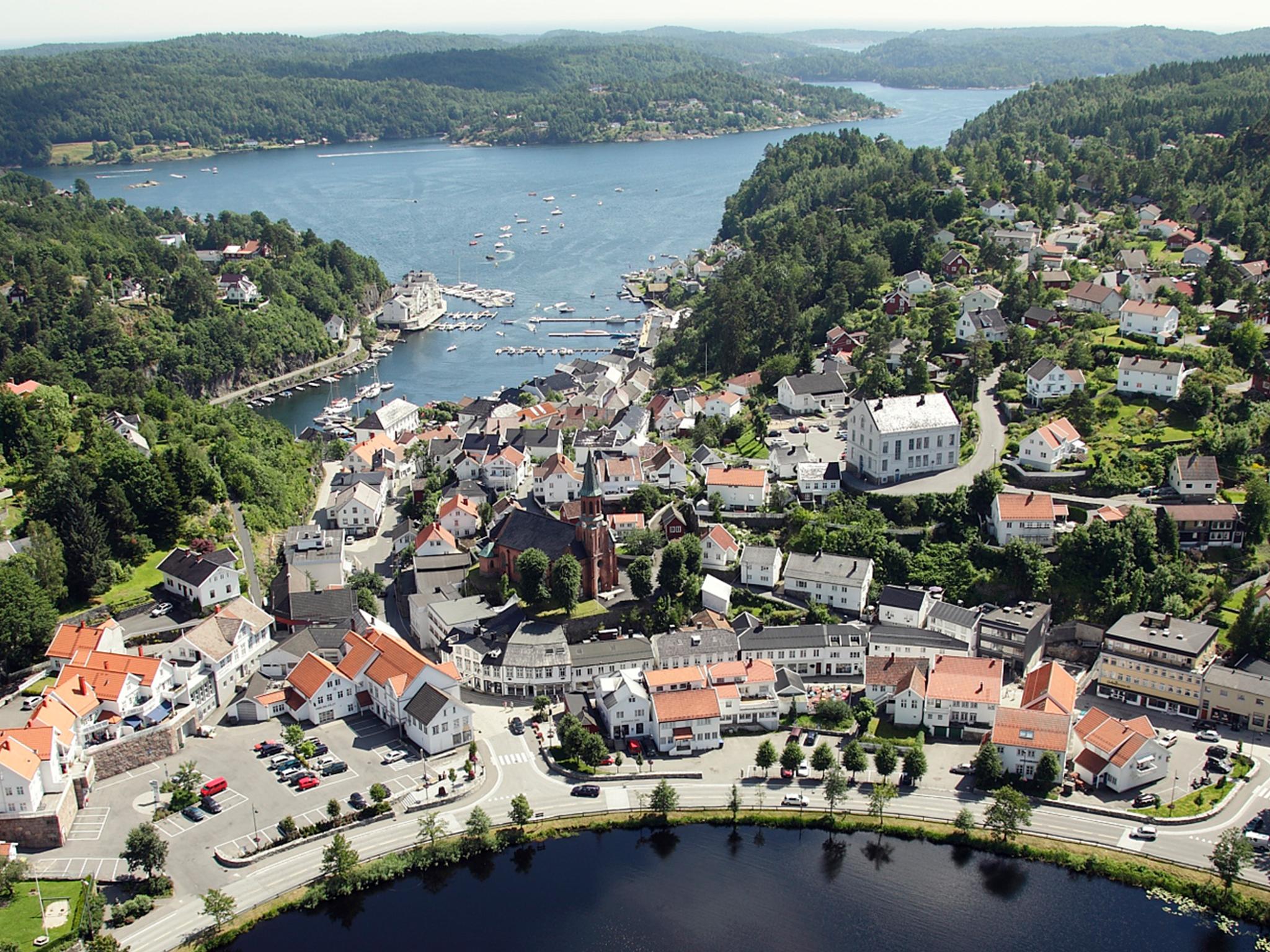 Den idylliske hvite sørlandsbyen Tvedestrand fra luften, mellom fjorden og innsjøen Tjenna.