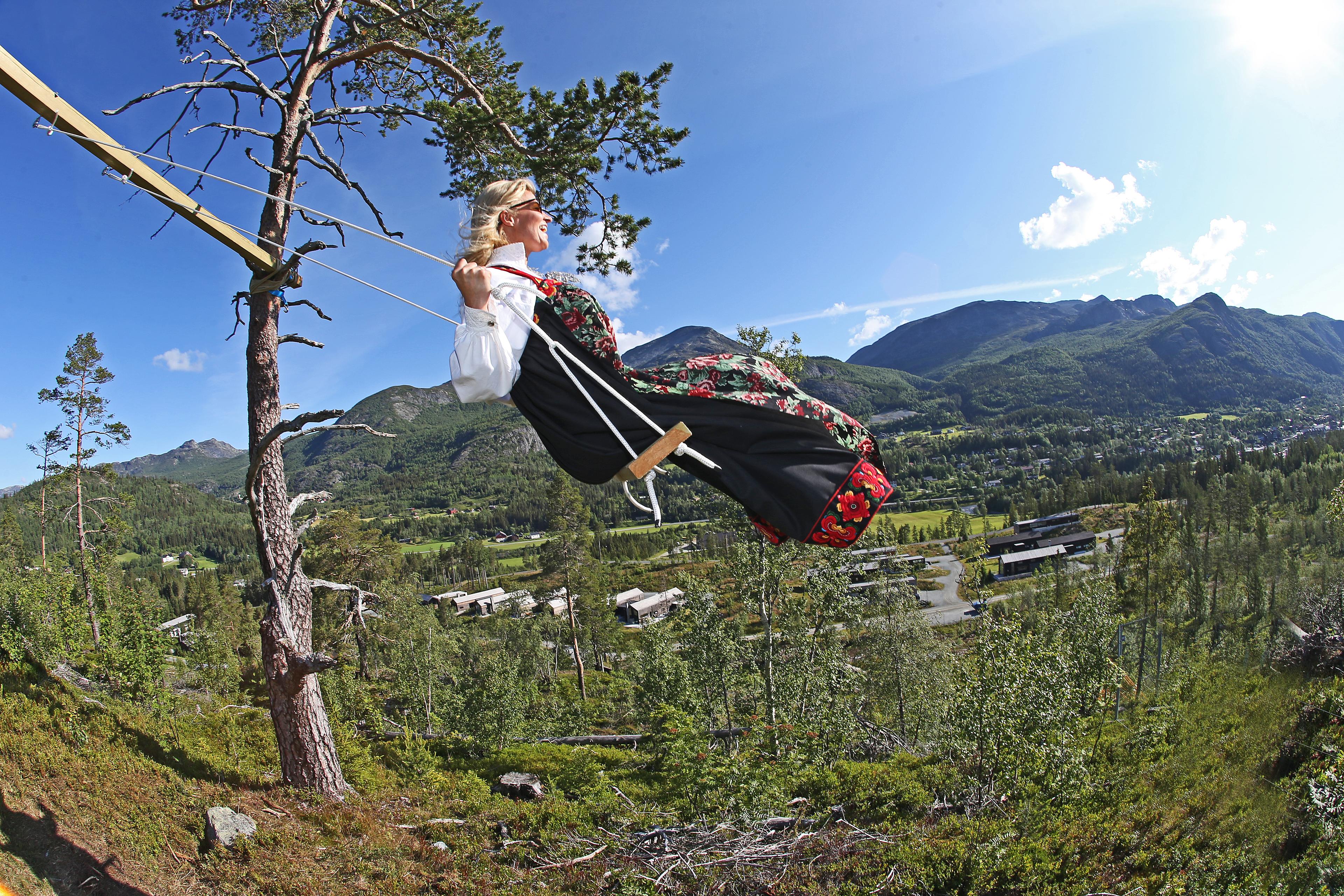 Una mujer, sentada en un columpio ataviada con el traje típico de Hemsedal, el "bunad", en el Este de Noruega.