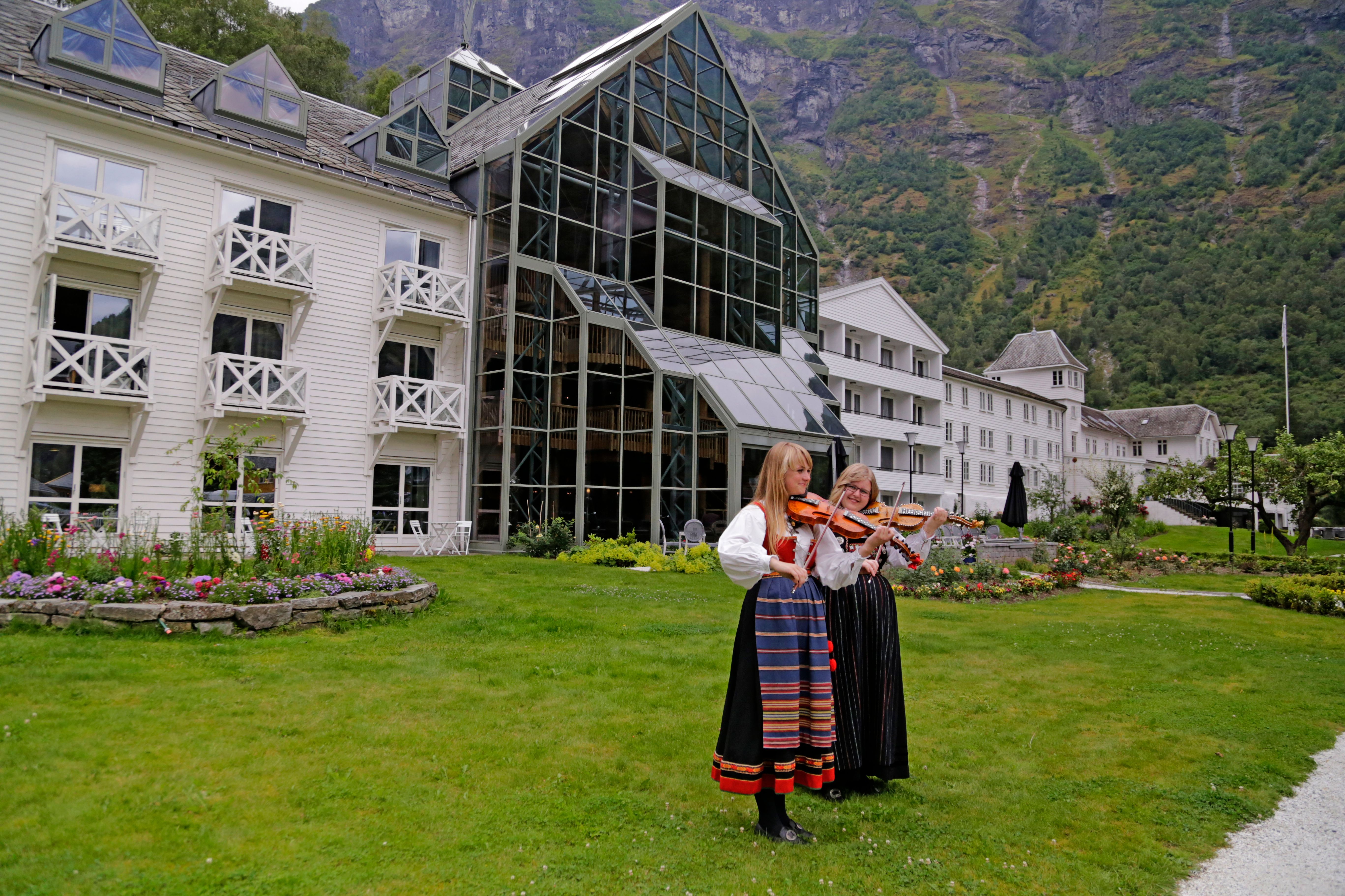 Two girls in traditional costumes playing violin in Flåm in Fjord Norway