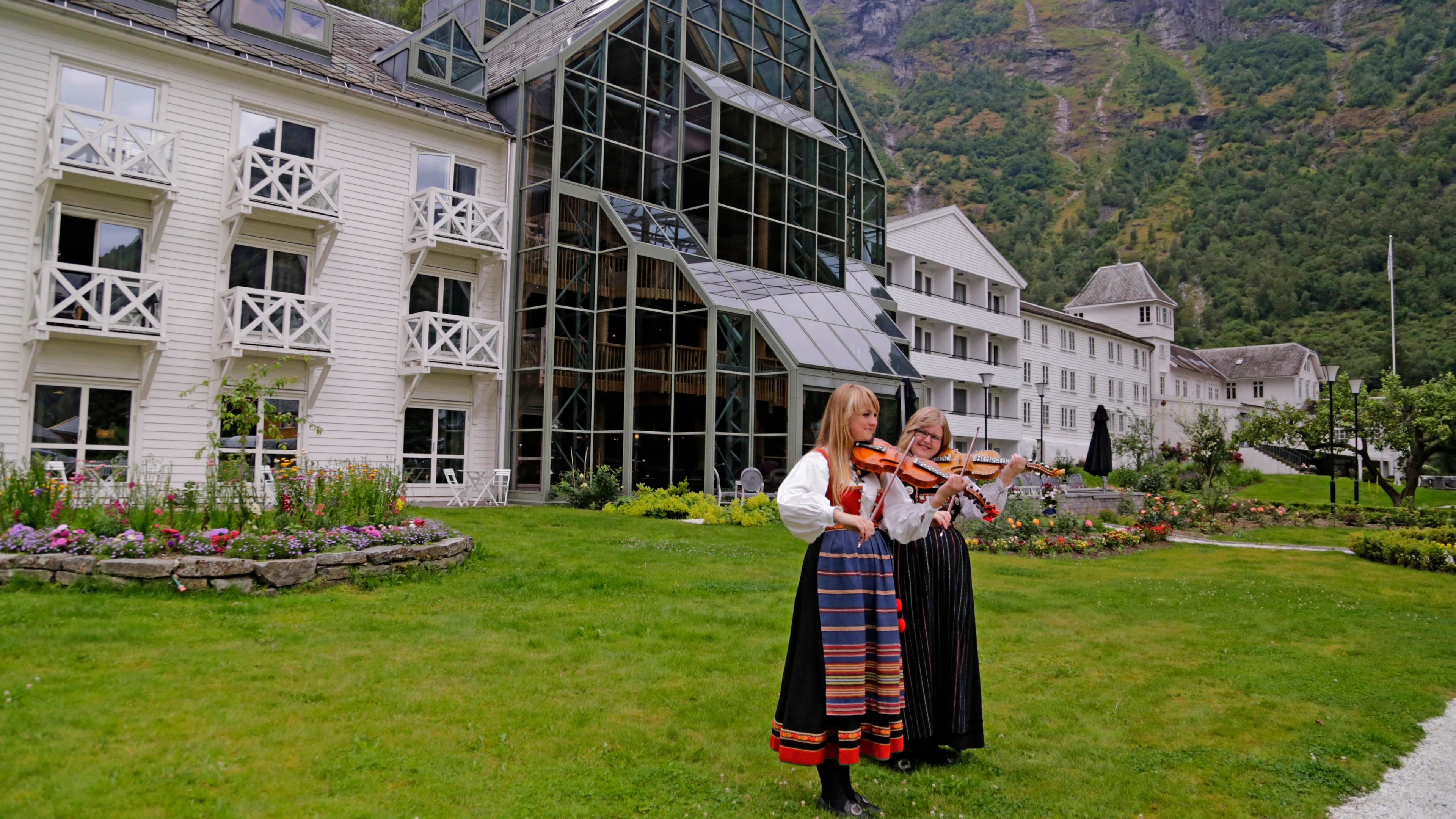 Two girls in traditional costumes playing violin in Flåm in Fjord Norway