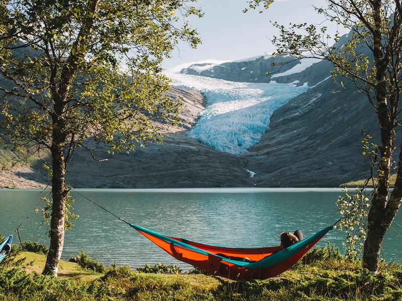 People in hammocks in front of the Svartisen glacier in Helgeland, Northern Norway