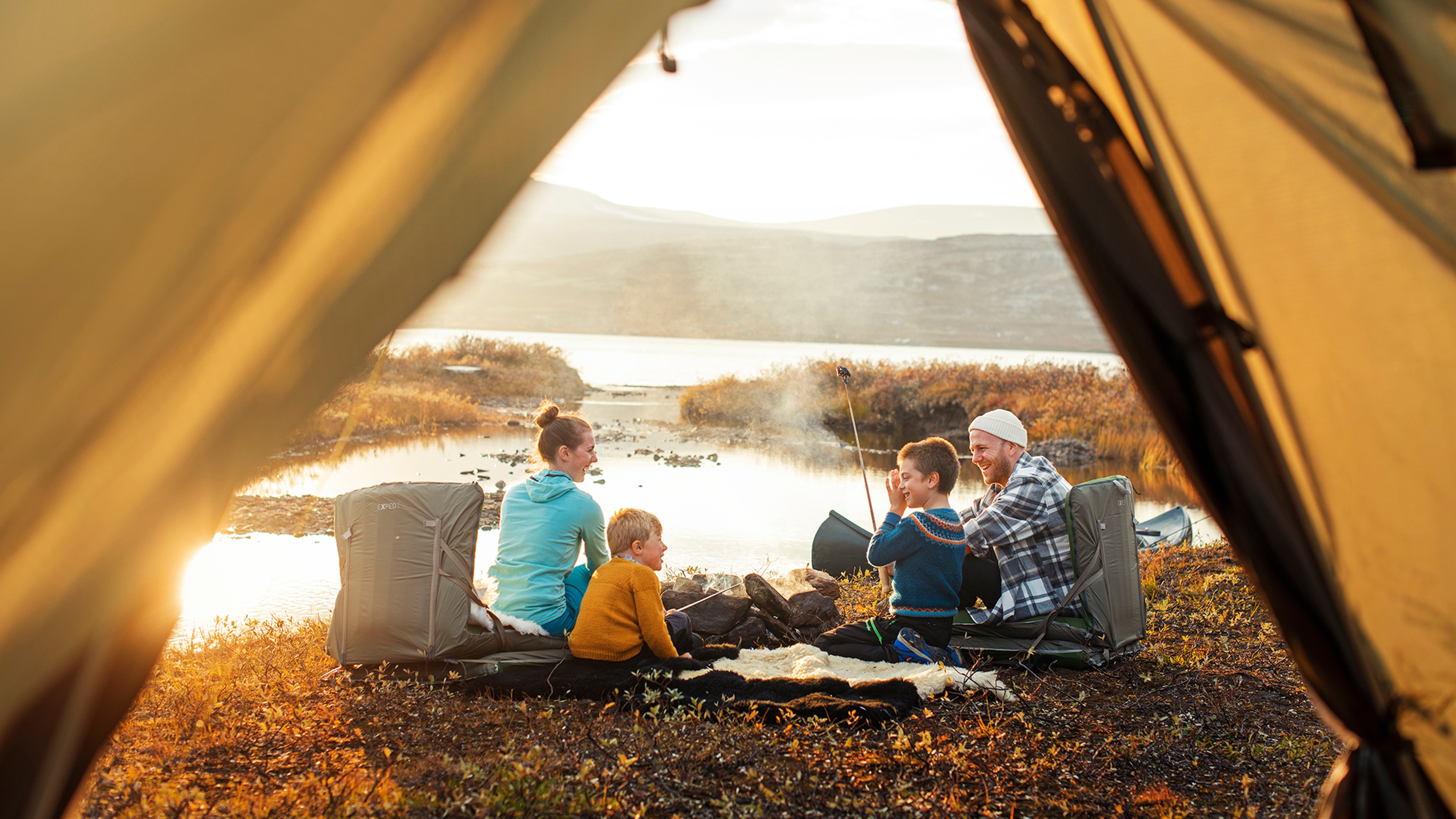 A family outside a tent in sunset in Oppdal in Trøndelag, Norway