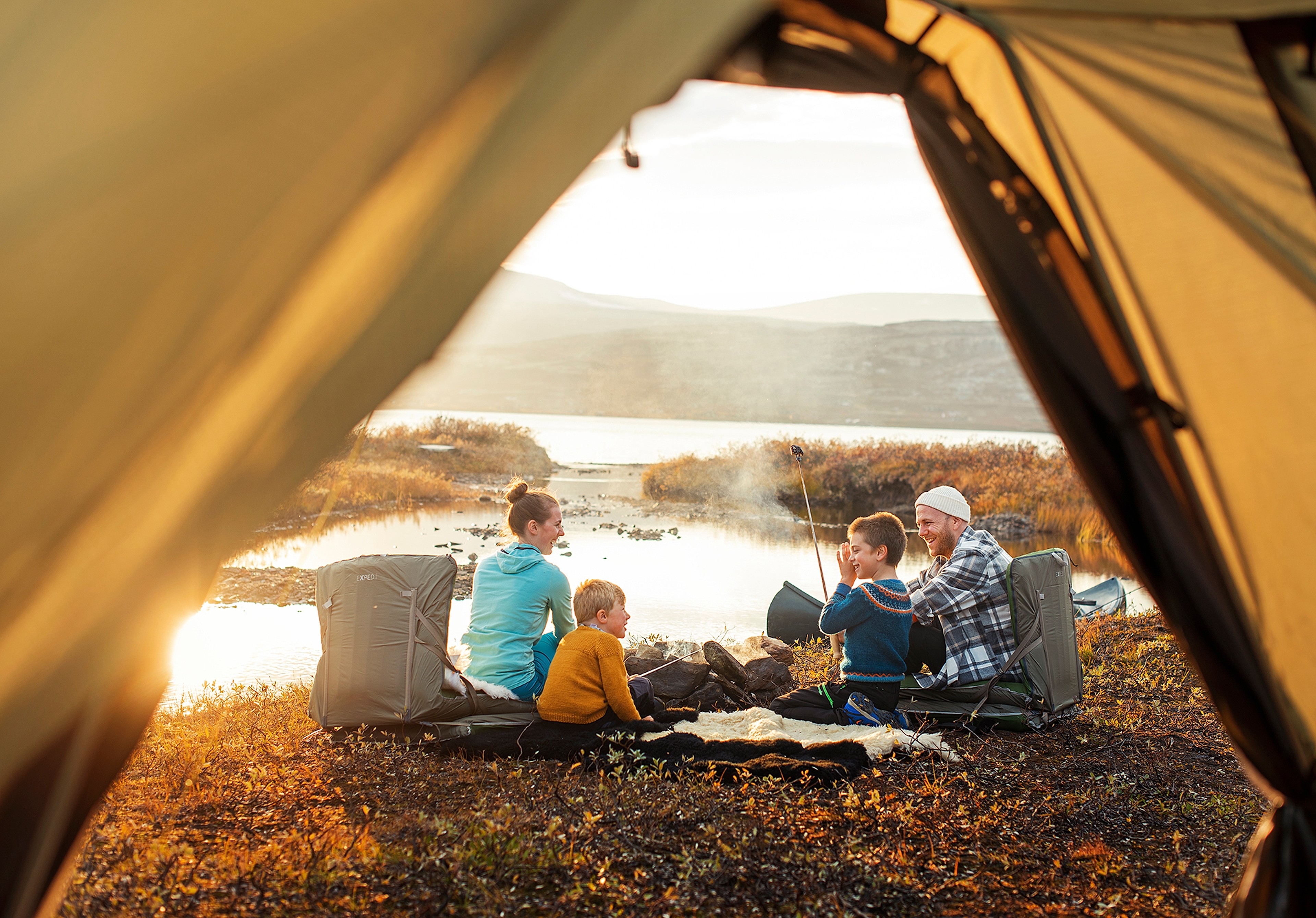 A family outside a tent in sunset in Oppdal in Trøndelag, Norway