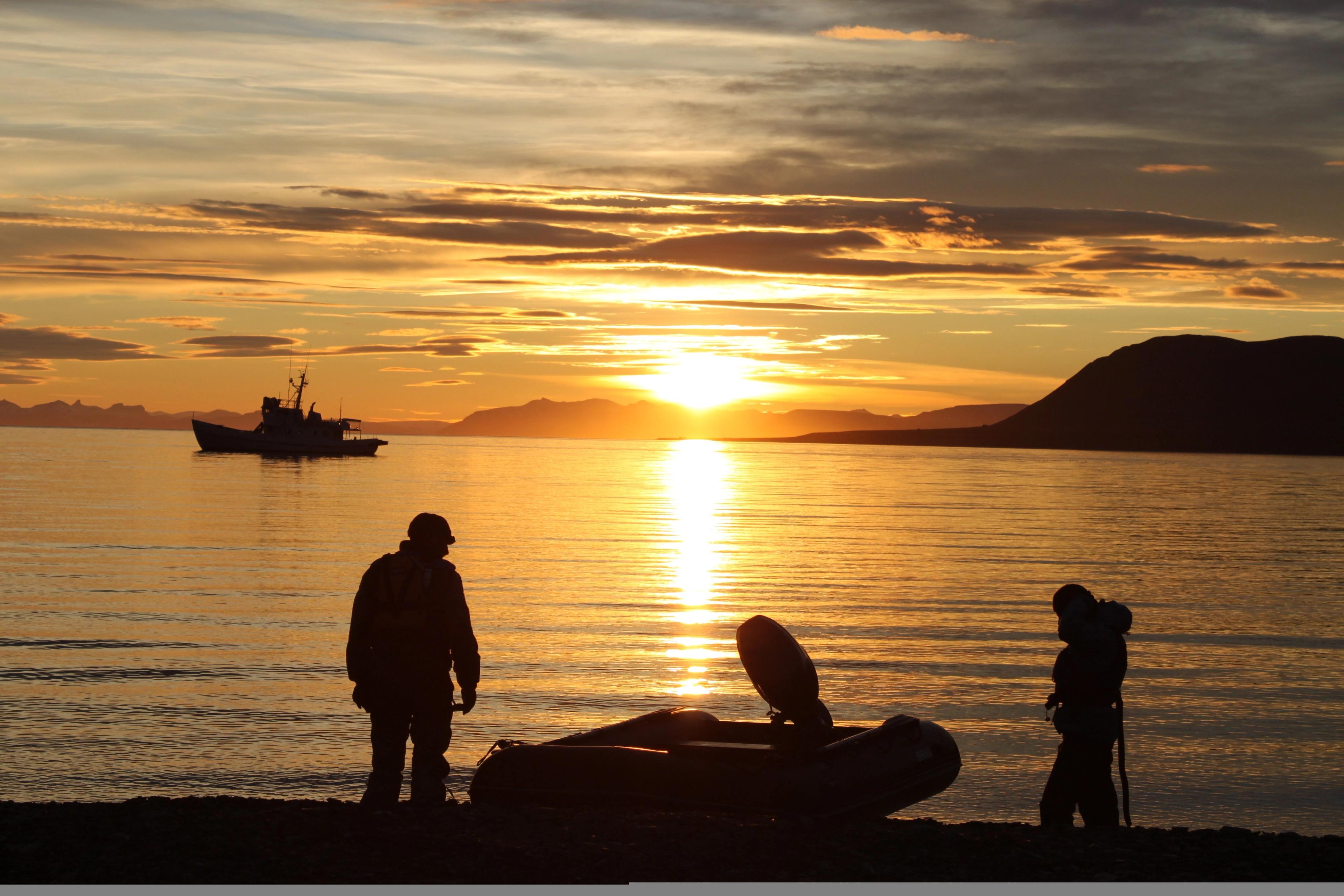 People by the sea in the midnight sun at Svalbard, Northern Norway