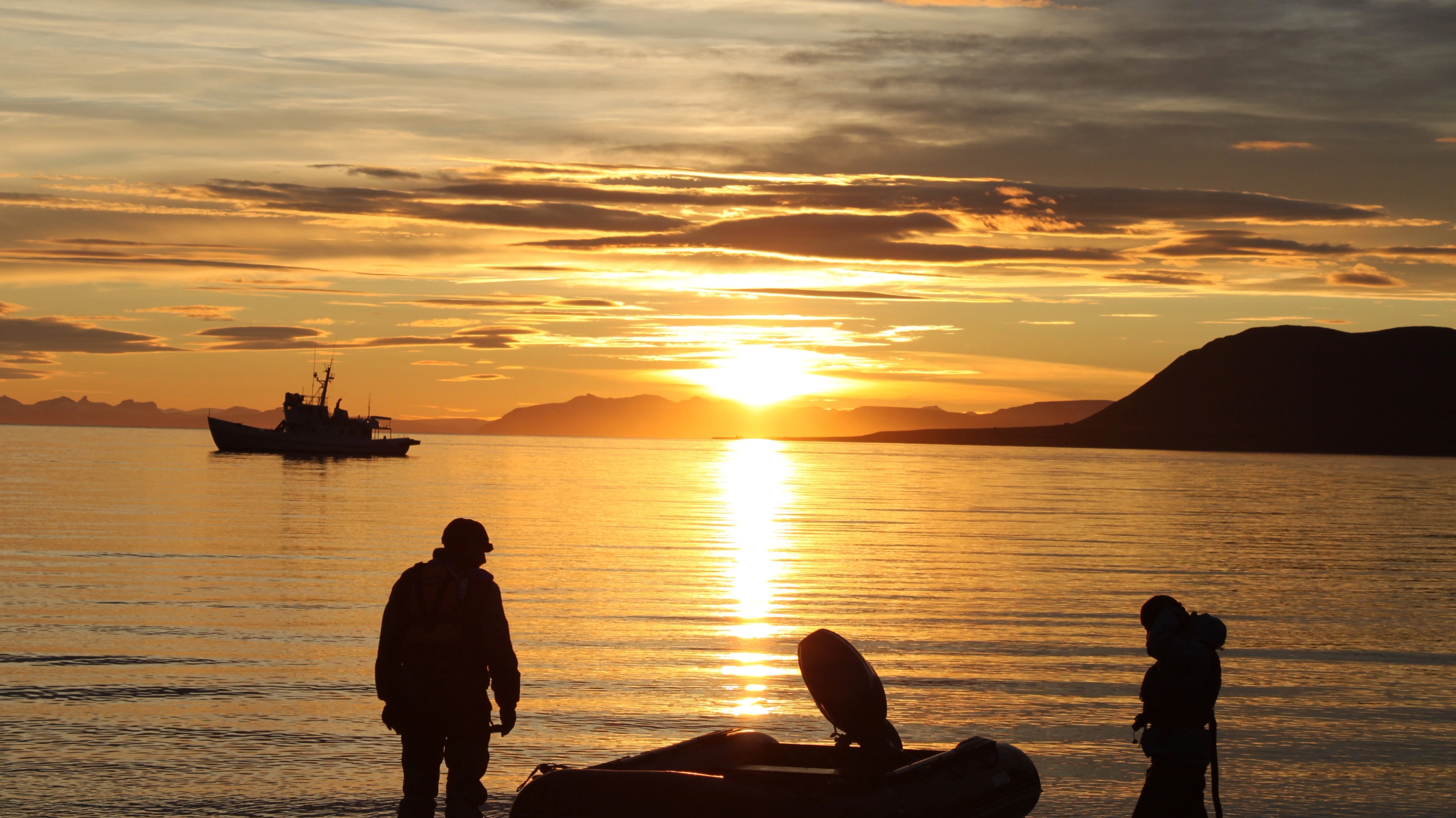 People by the sea in the midnight sun at Svalbard, Northern Norway