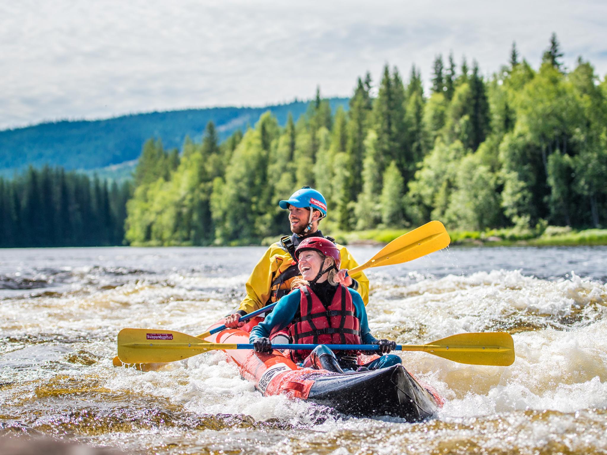 Two people packrafting down the river in Trysil, Eastern Norway