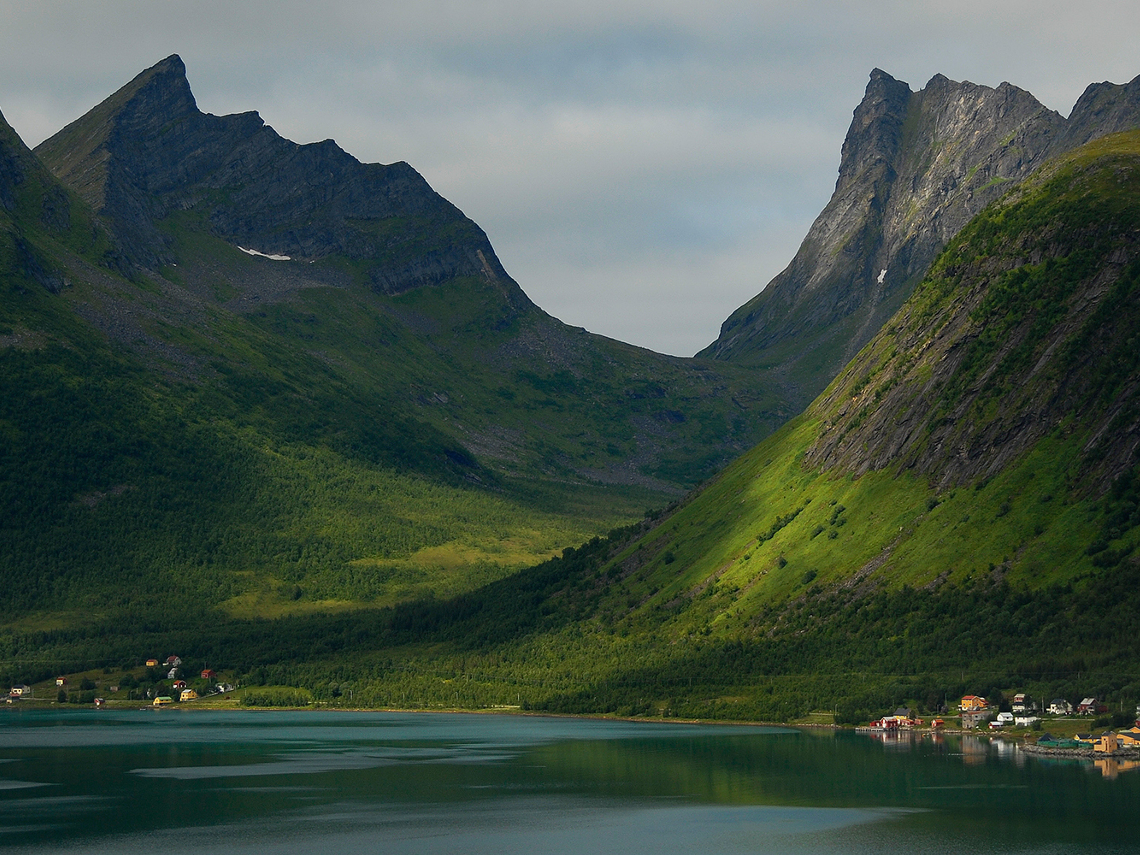 Bratte fjell i Senja som stiger opp fra sjøen