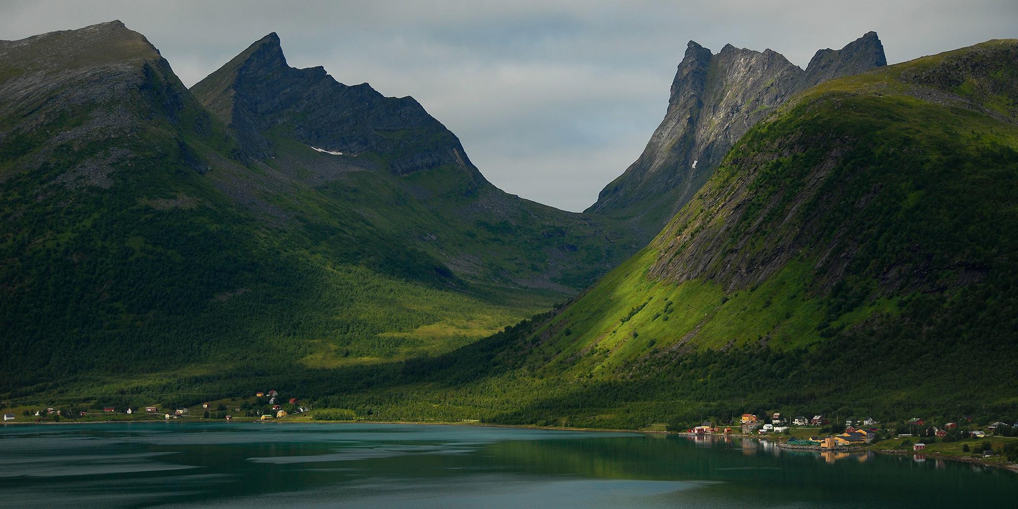 Bratte fjell i Senja som stiger opp fra sjøen