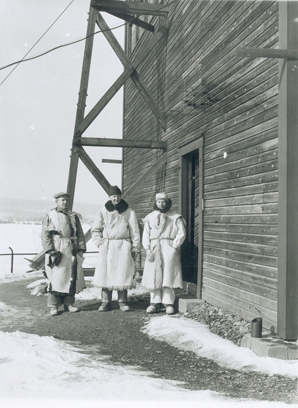 The stone carvers Ivar Broe, Nils Jønsson, and Karl Kjær in front of the shed