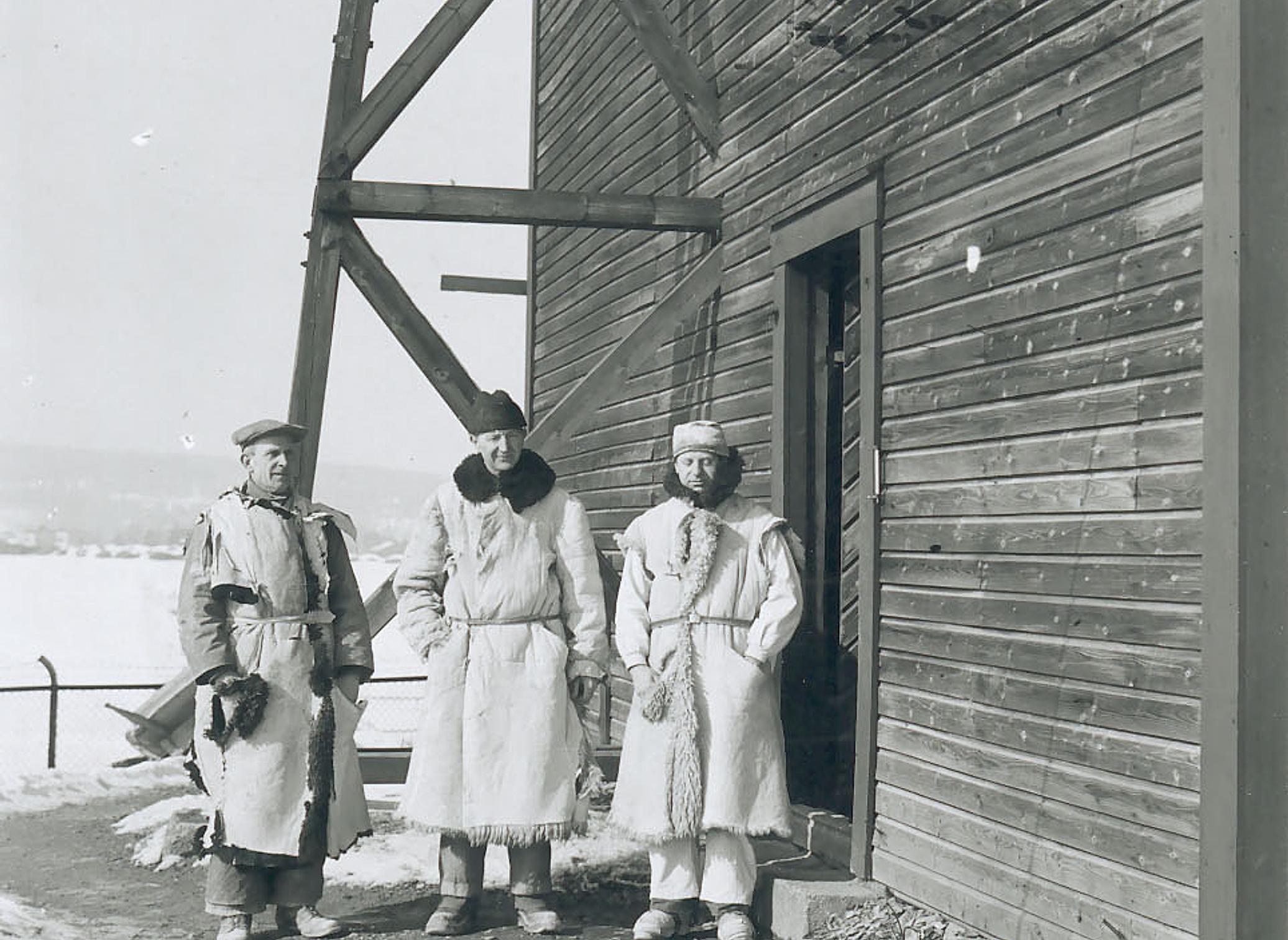The stone carvers Ivar Broe, Nils Jønsson, and Karl Kjær in front of the shed
