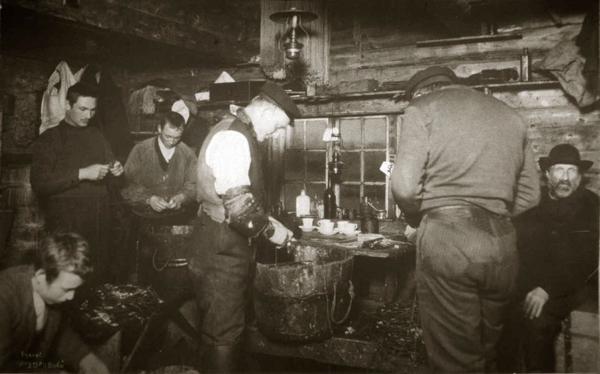 Black and white image of a group of fishermen inside a fisherman's cabin in Lofoten in Northern Norway around year 1900