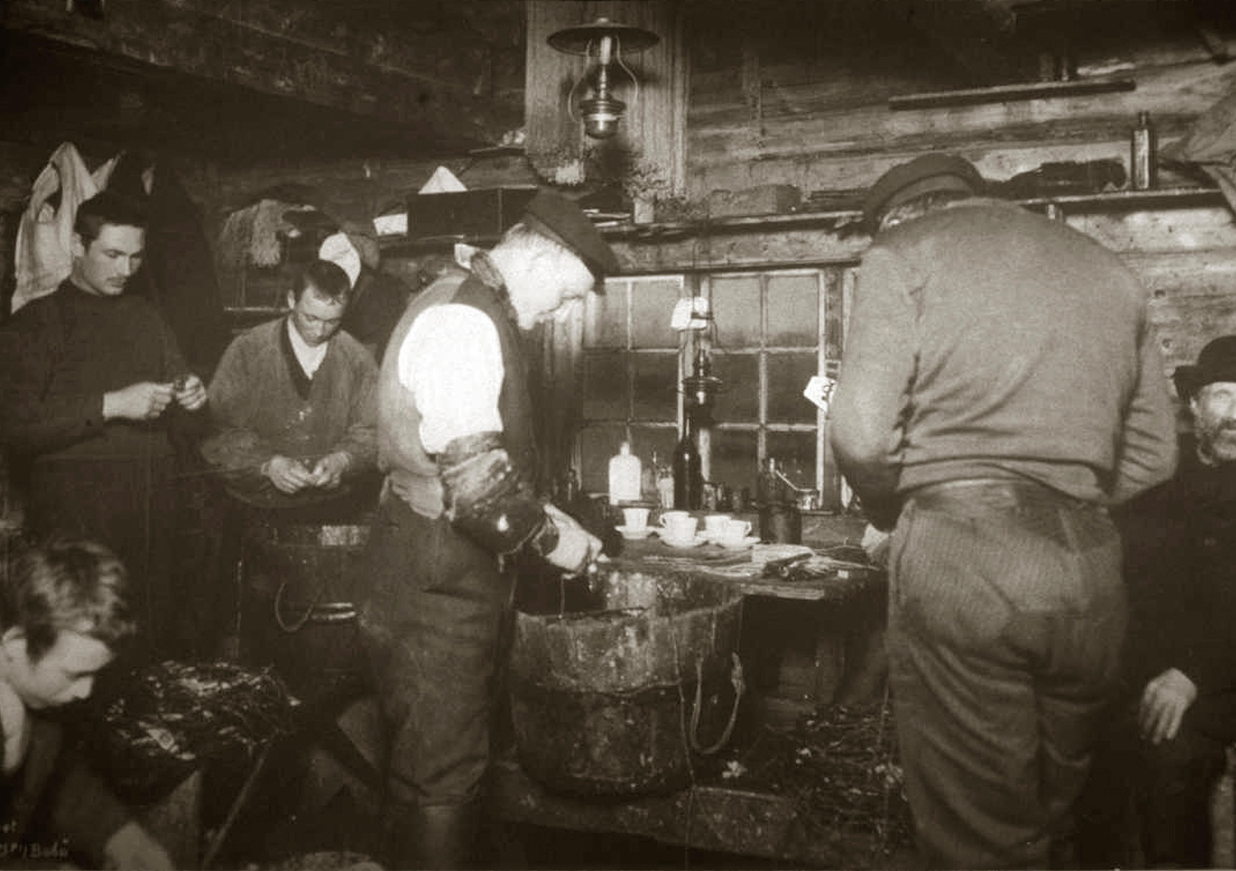Black and white image of a group of fishermen inside a fisherman's cabin in Lofoten in Northern Norway around year 1900
