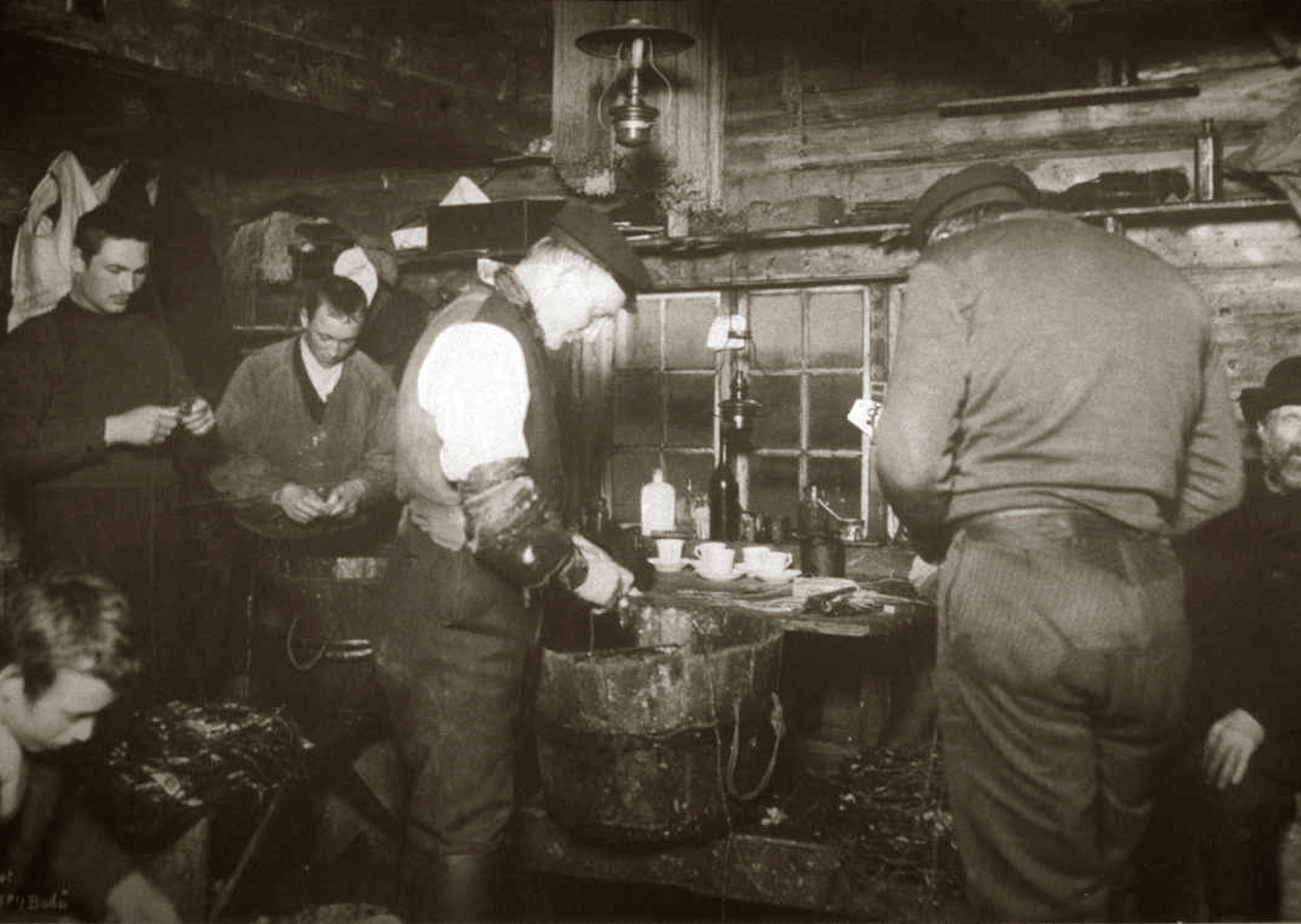 Black and white image of a group of fishermen inside a fisherman's cabin in Lofoten in Northern Norway around year 1900