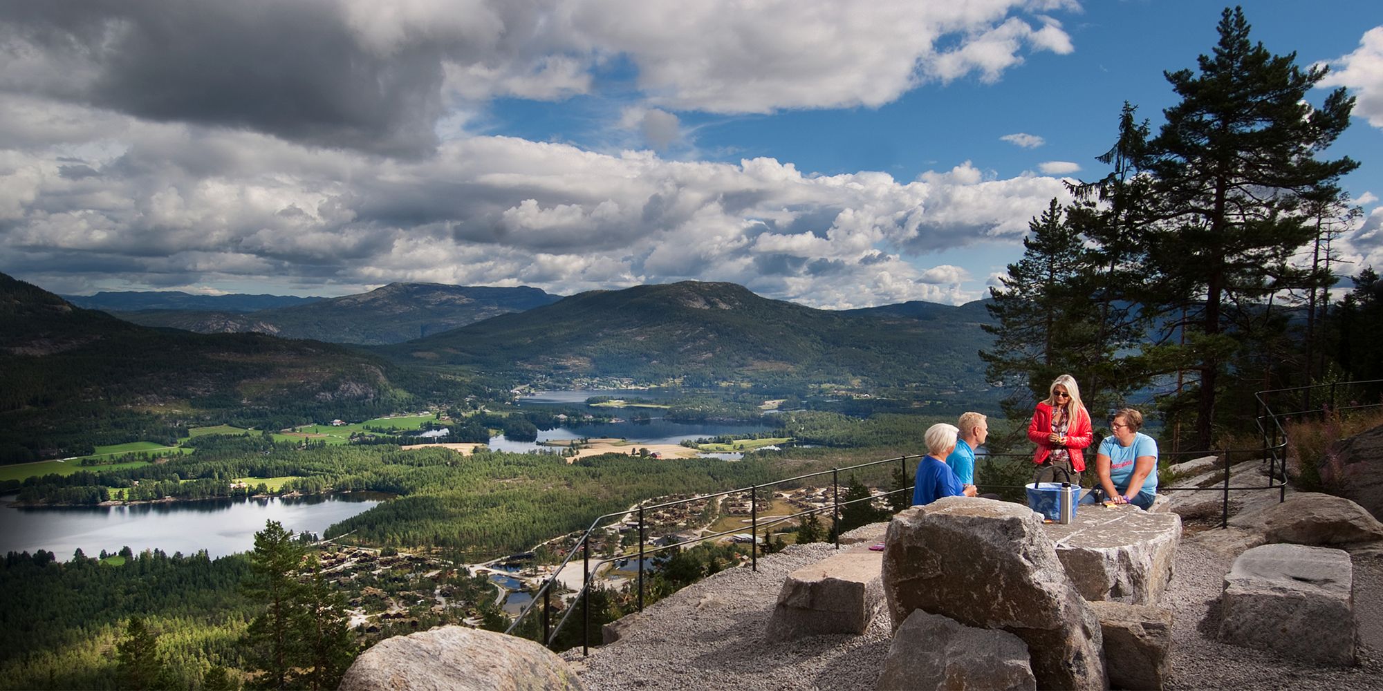 Four people having a picnic at a viewpoint in Vrådal