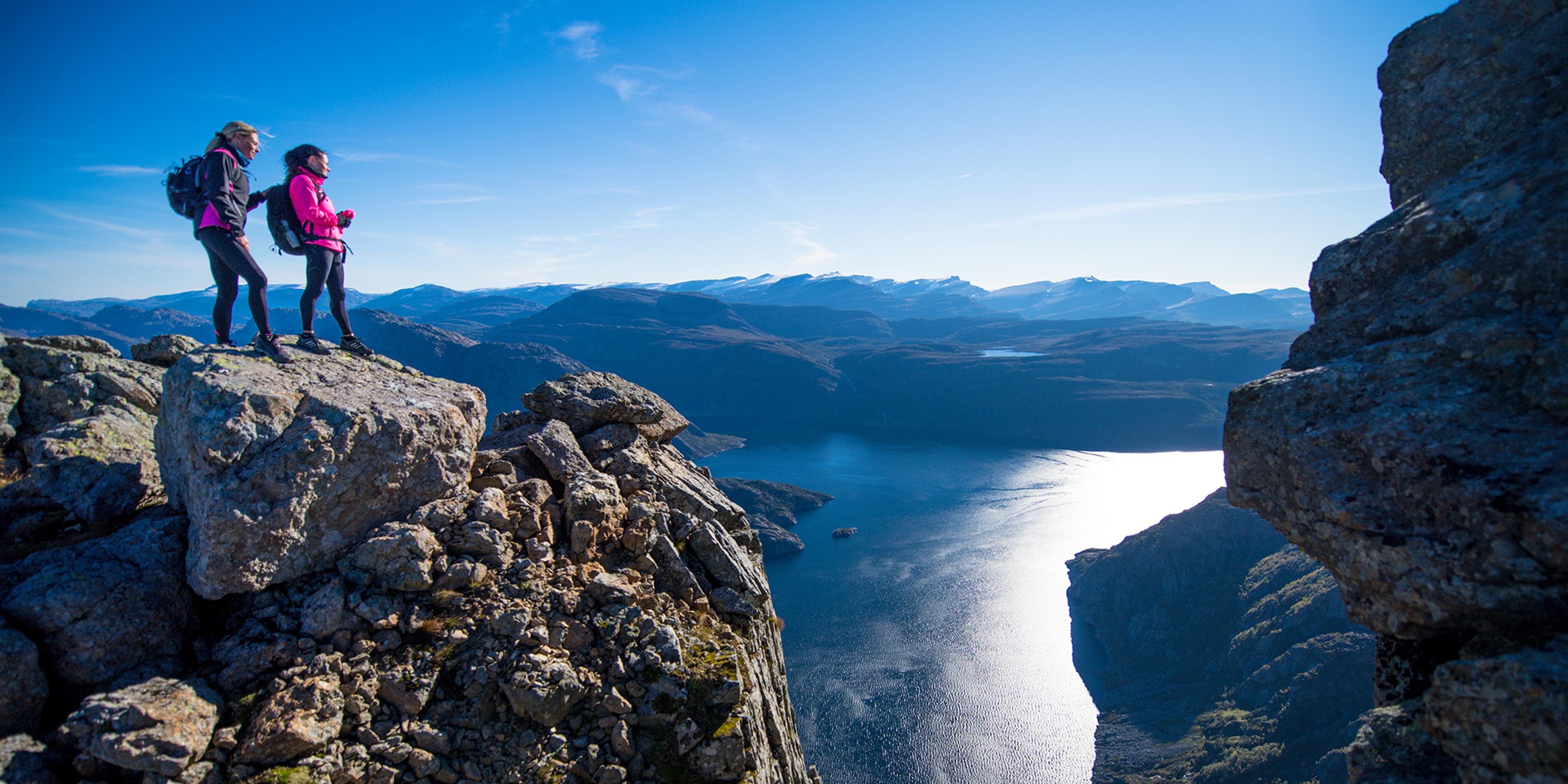 Two people on Hornelen in Bremanger, Norway on a sunny summer day