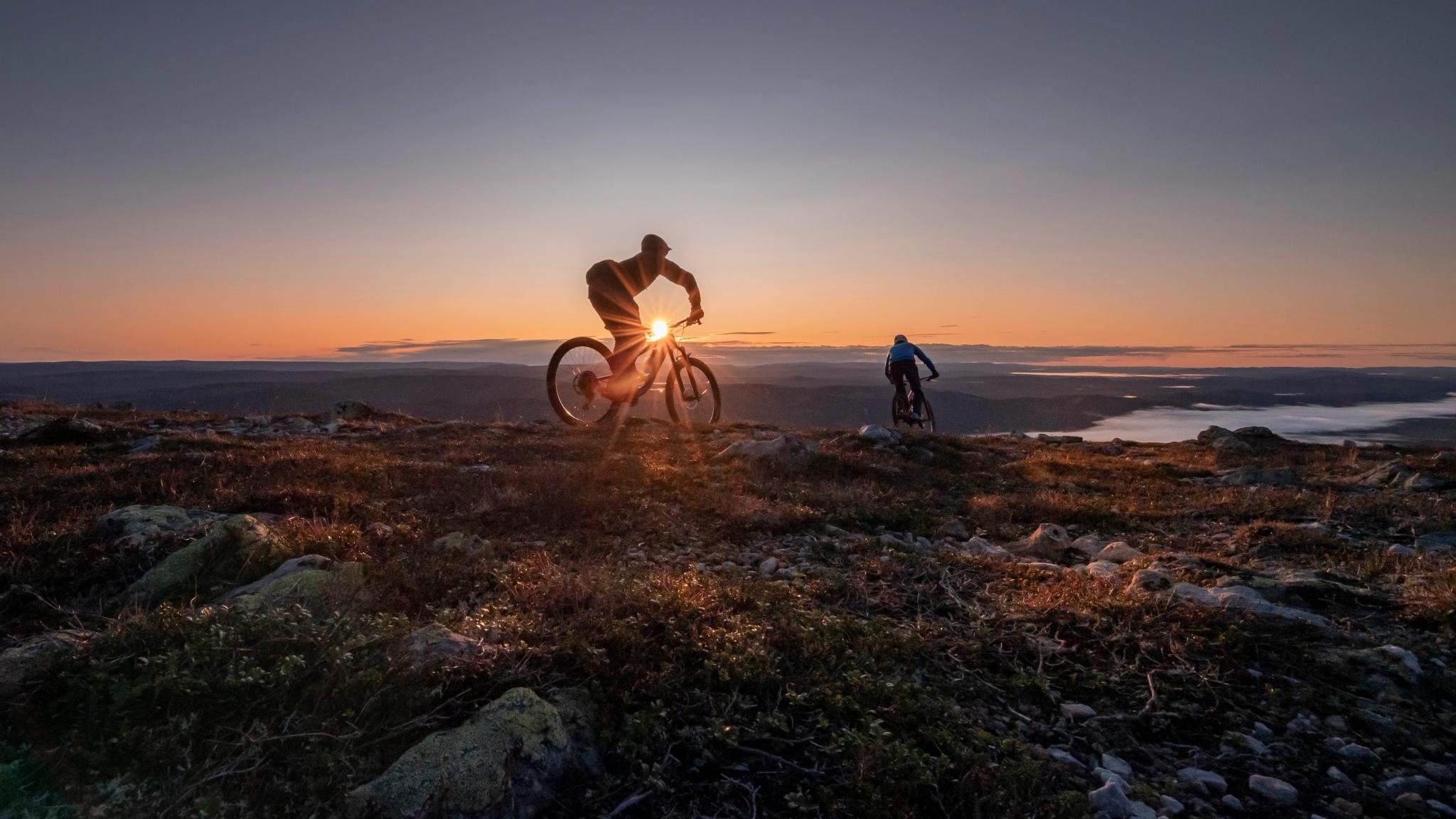 Two people biking in sunset in Trysil