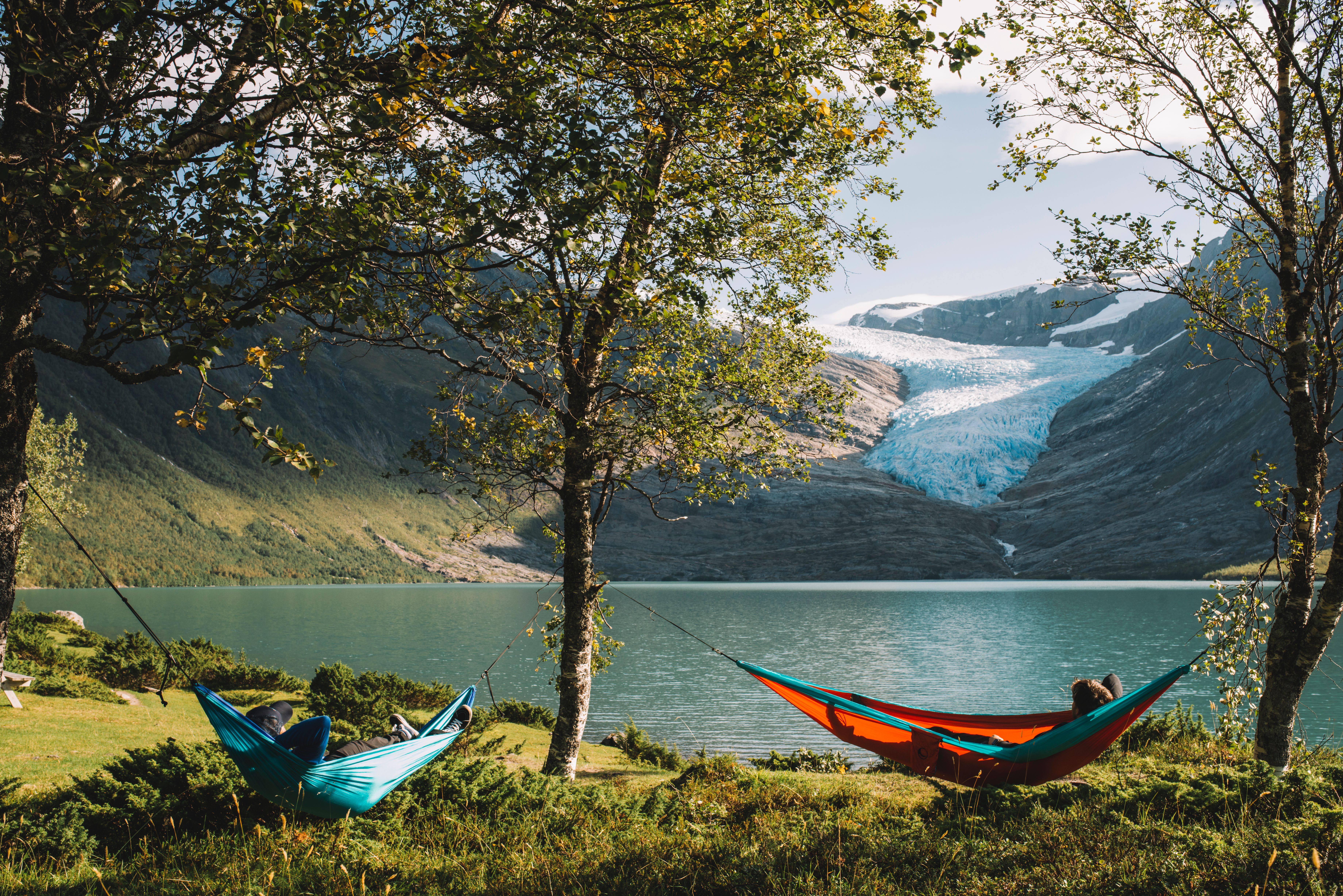 Folk i hengekøyer foran Svartisen på Helgeland i Nord-Norge