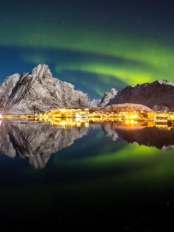 The northern lights over the fishing village Reine in Lofoten, Northern Norway