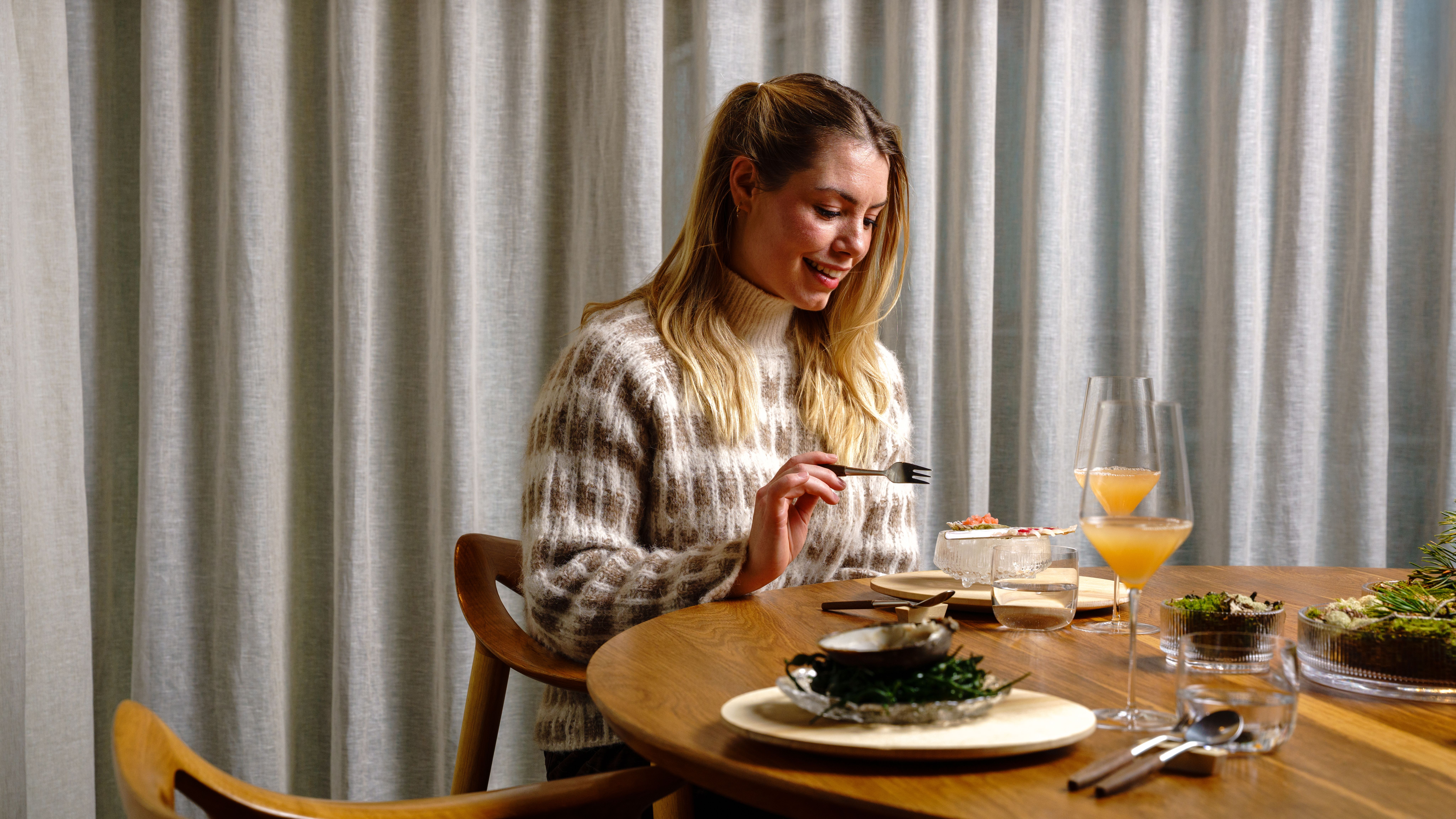 Woman enjoying fine dining from Credo restaurant at The National Library in Oslo